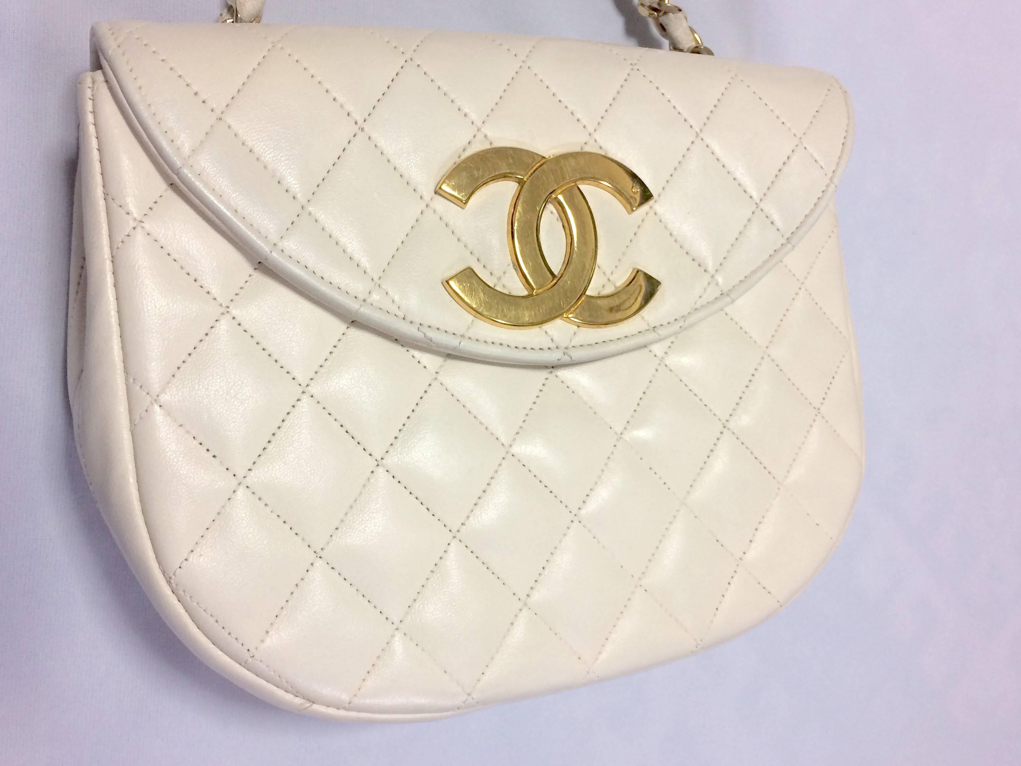 1980s. Vintage CHANEL ivory white lambskin 2.55 chain shoulder bag with large golden CC motif and oval flap.

Here is another rare piece, a hard-to-find vintage treasury bag from Chanel back in the 80's.

The unique thing about this purse is its