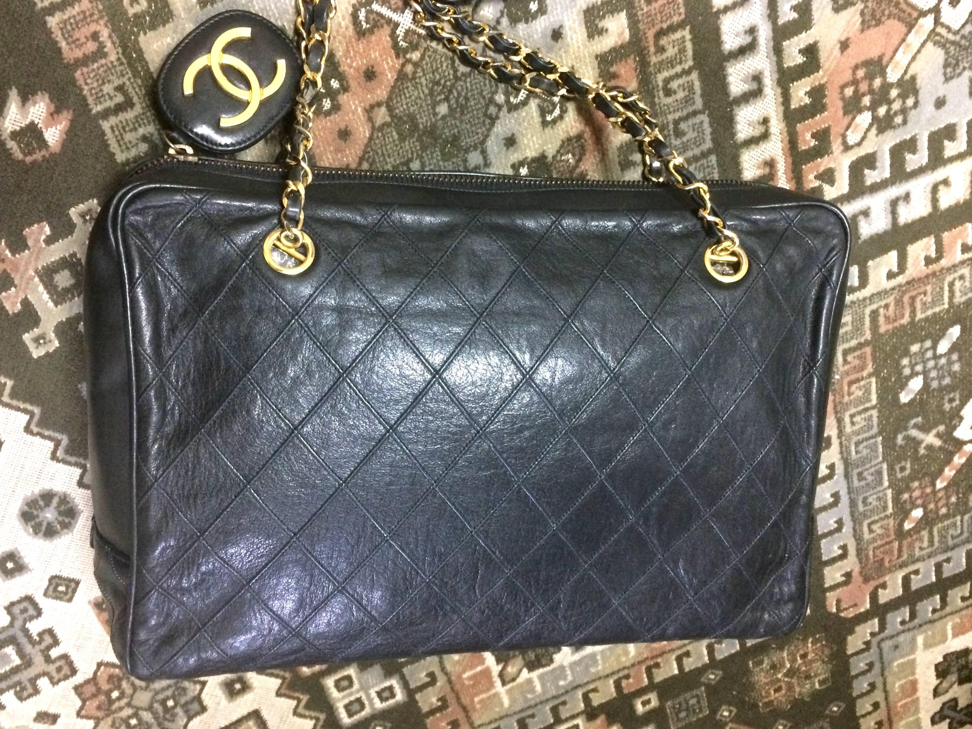 1980s. Vintage CHANEL black goatskin classic large shoulder bag with gold tone chain straps and a large oval square golden CC mark charm.

Introducing a vintage CHANEL black goatskin with stitches shoulder bag with gold tone chain straps. 
One of