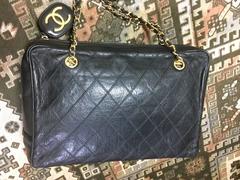 Vintage CHANEL black goatskin shoulder bag with gold tone chains and cc charm.