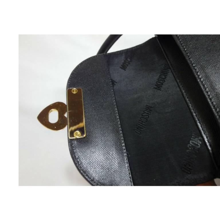 Vintage MOSCHINO black leather handbag, oval shape purse with golden logo motif. For Sale 1