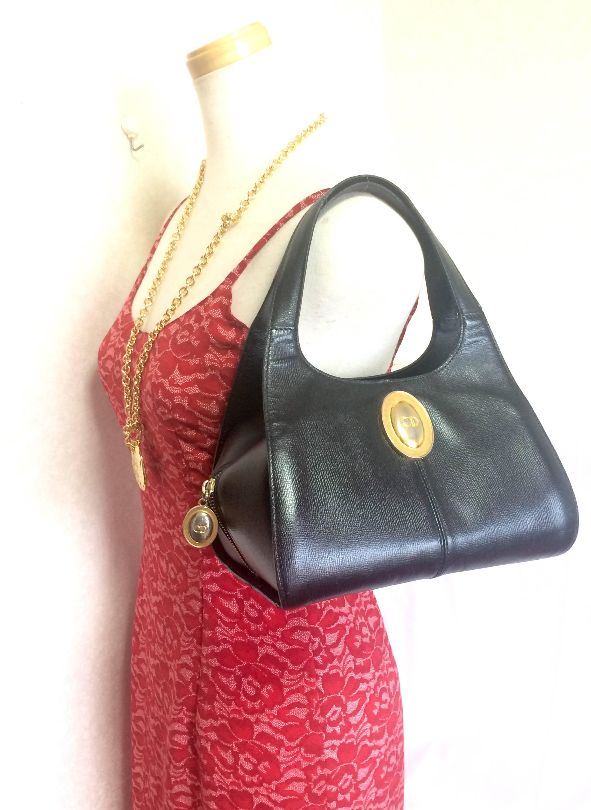 1990s. Vintage Christian Dior black grained leather handbag with golden oval shape CD logo motif. Classic style but rare design. Daily use.

Introducing another adorable vintage purse from Christian Dior back in the 90's.
If you are looking for a