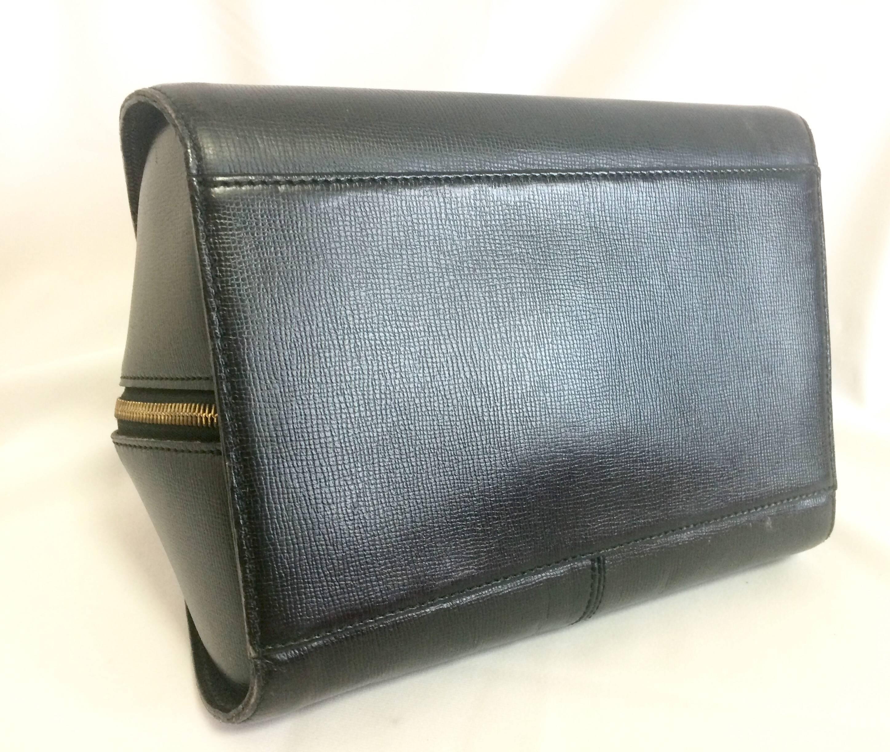 Women's Vintage Christian Dior grained black leather handbag with oval golden CD logo. For Sale