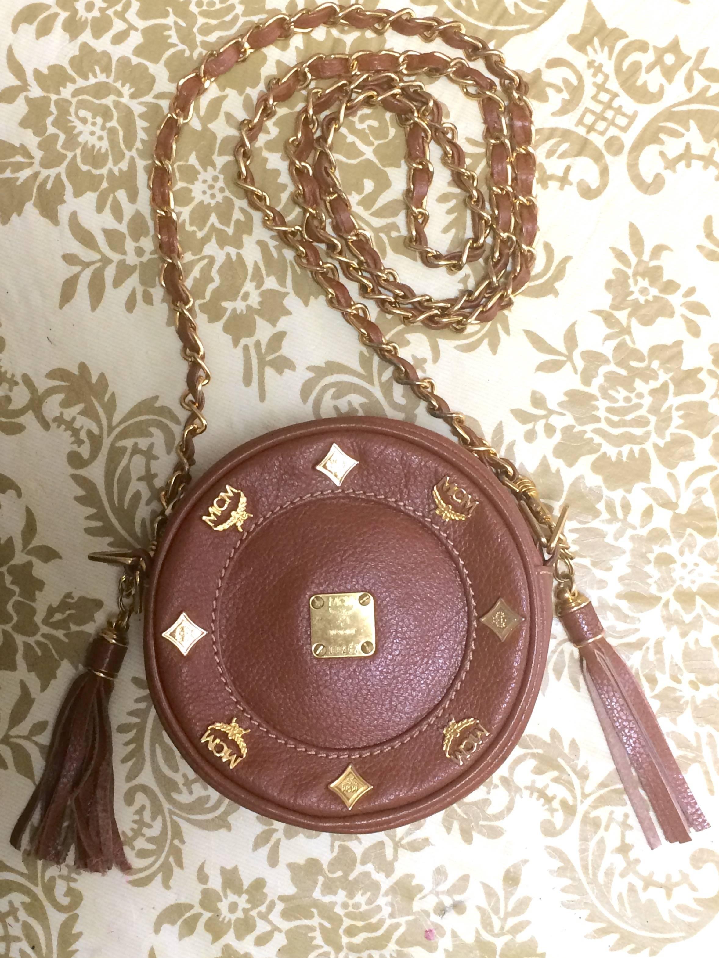 1990s. Vintage MCM brown leather round  mini Suzy Wong shoulder bag with golden logo motifs. trimmings. Designed by Michael Cromer.

MCM has been back in the fashion trend again!!
Now it's considered to be one of the must-have designer in