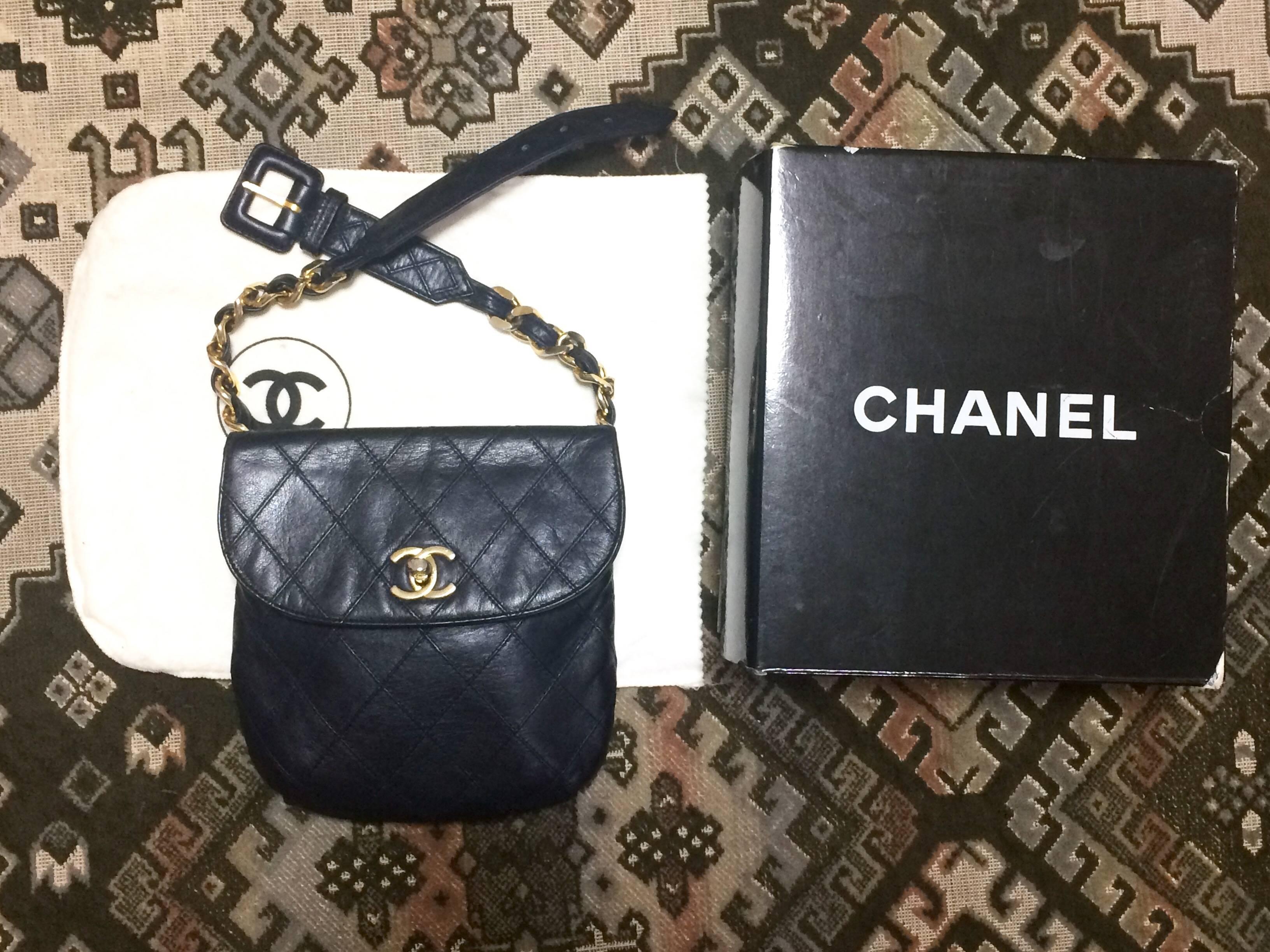 1990s. Vintage CHANEL dark navy leather waist purse, fanny pack with golden thick chain belt and CC closure hock. 24", 24.5", 25", 25.5", 26", and 26.5"(62cm through 68cm) .

Featuring a gold tone CC turn lock closure,