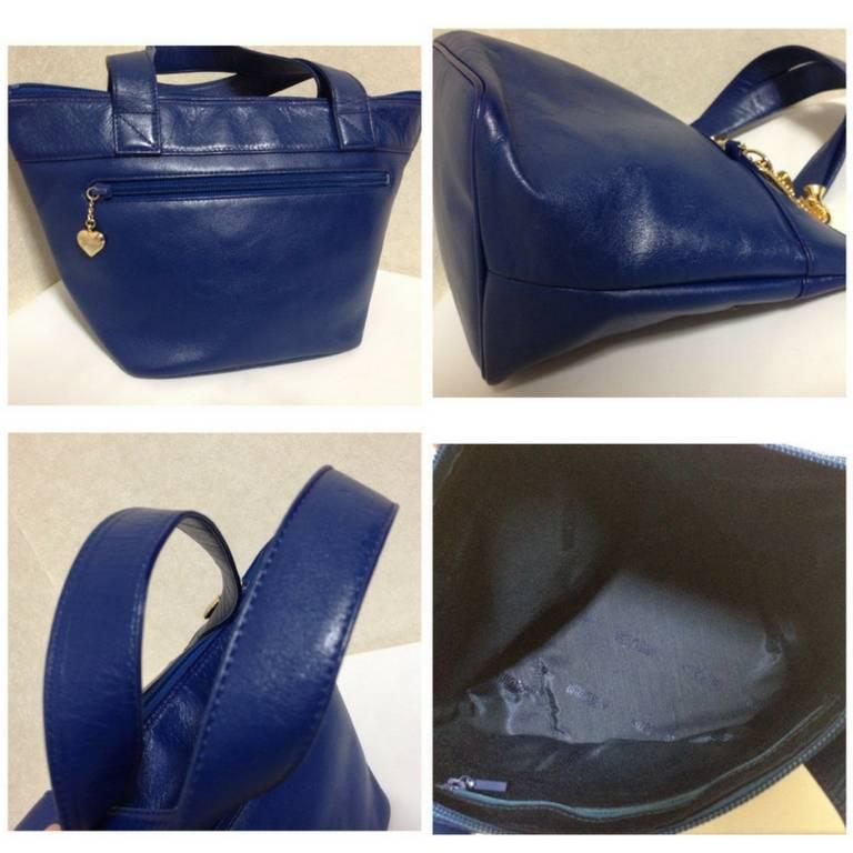 Blue Vintage Moschino navy blue leather classic tote bag with golden dangling charm. For Sale