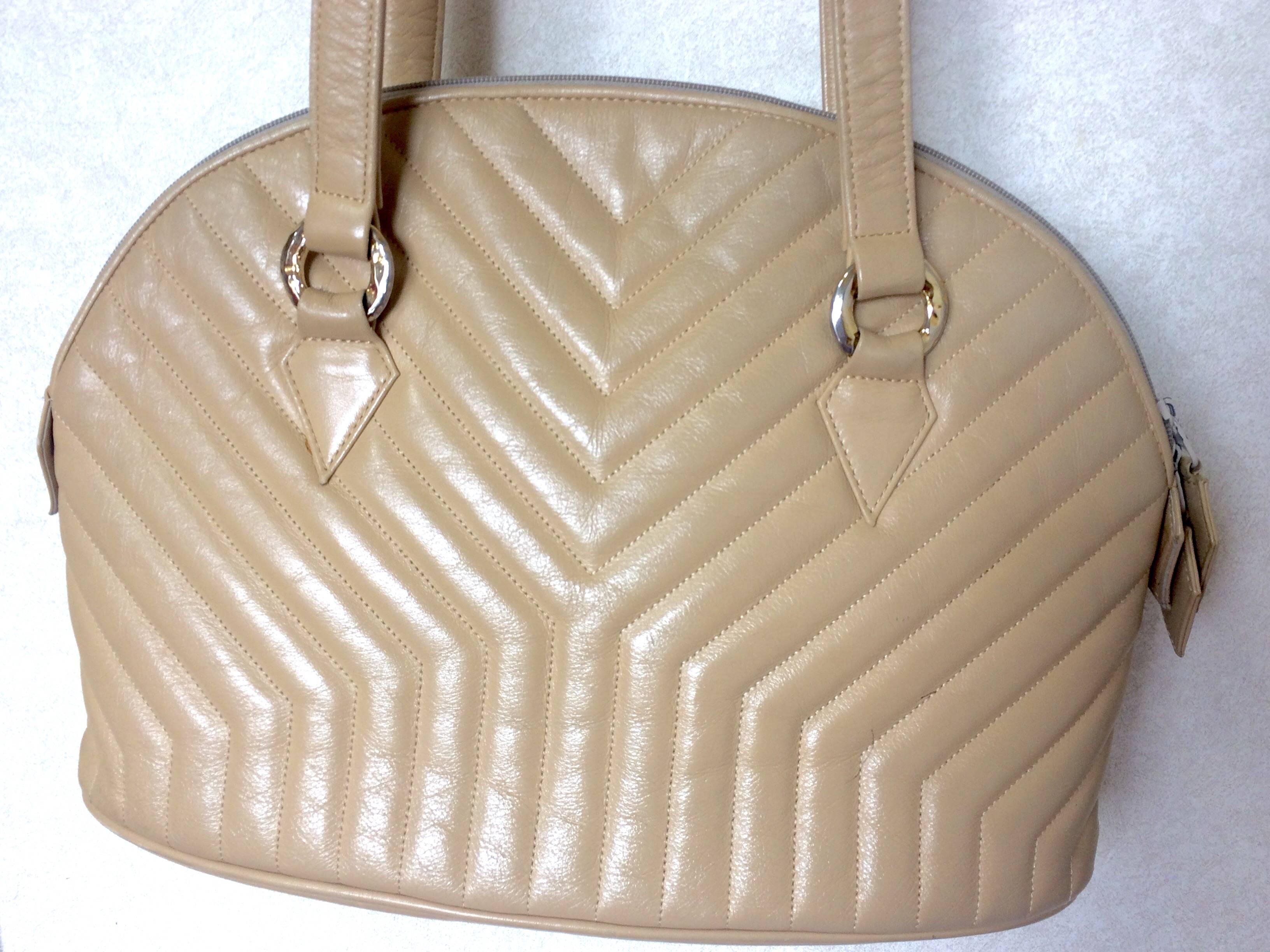 1990s. Vintage Yves Saint Laurent beige leather tote bag with Y, Chevron stitch in bolide purse shape. Perfect vintage bag from YSL back in the era.

Introducing a classic bolide shape design beige leather shoulder bag from Yves Saint Laurent in the