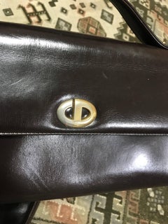 Vintage Christian Dior dark brown leather shoulder bag with CD motif and strap.
