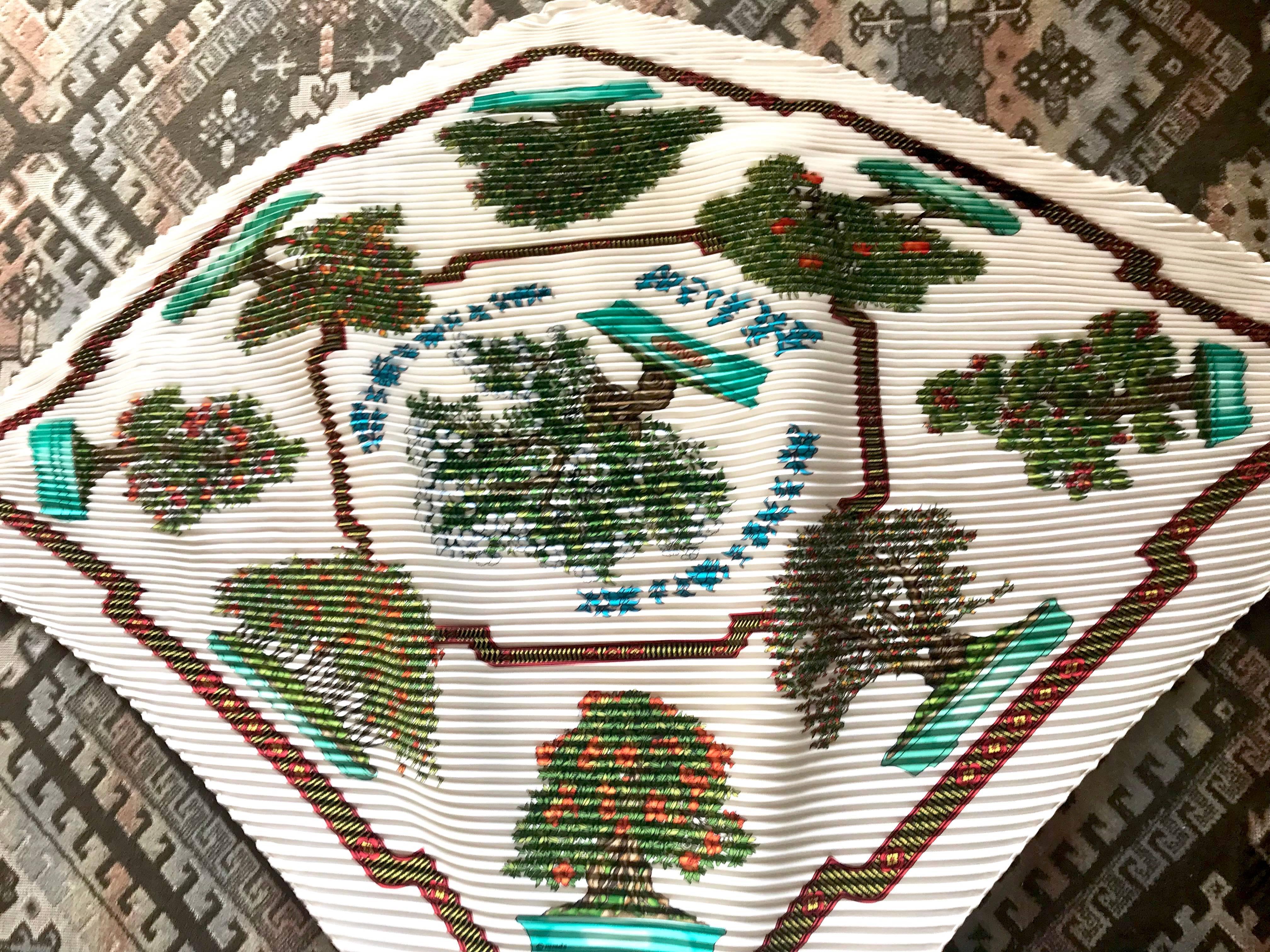 1990s. Vintage HERMES carre pleated silk scarf, harness, BONSAI flower and fruits print in white, green, blue, red, and orange. Rare Bonsai.     

This is a 100% twill, pleated silk carre scarf from HERMES in the 90s. 
The BONSAI print is so popular