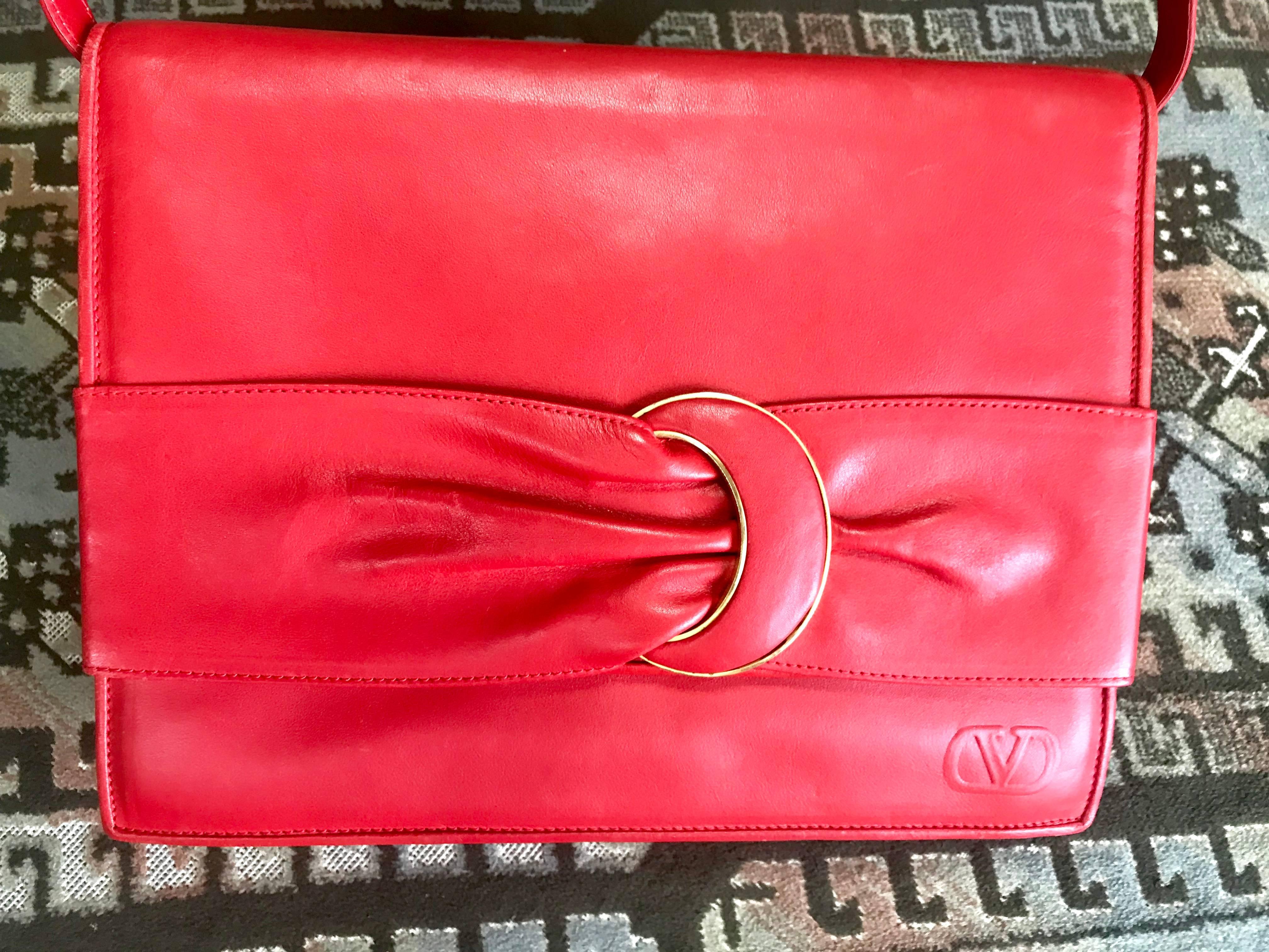 1980s. Vintage Valentino Garavani orange red leather clutch shoulder bag with a large gathered buckle design flap and V motif. Must have.

This is a vintage Valentino Garavani orange red genuine leather back in the old era.
Featuring a unique