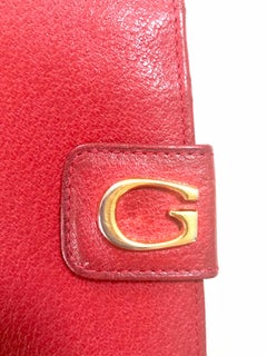 Vintage Gucci red pigskin leather wallet with golden G logo hardware closure.