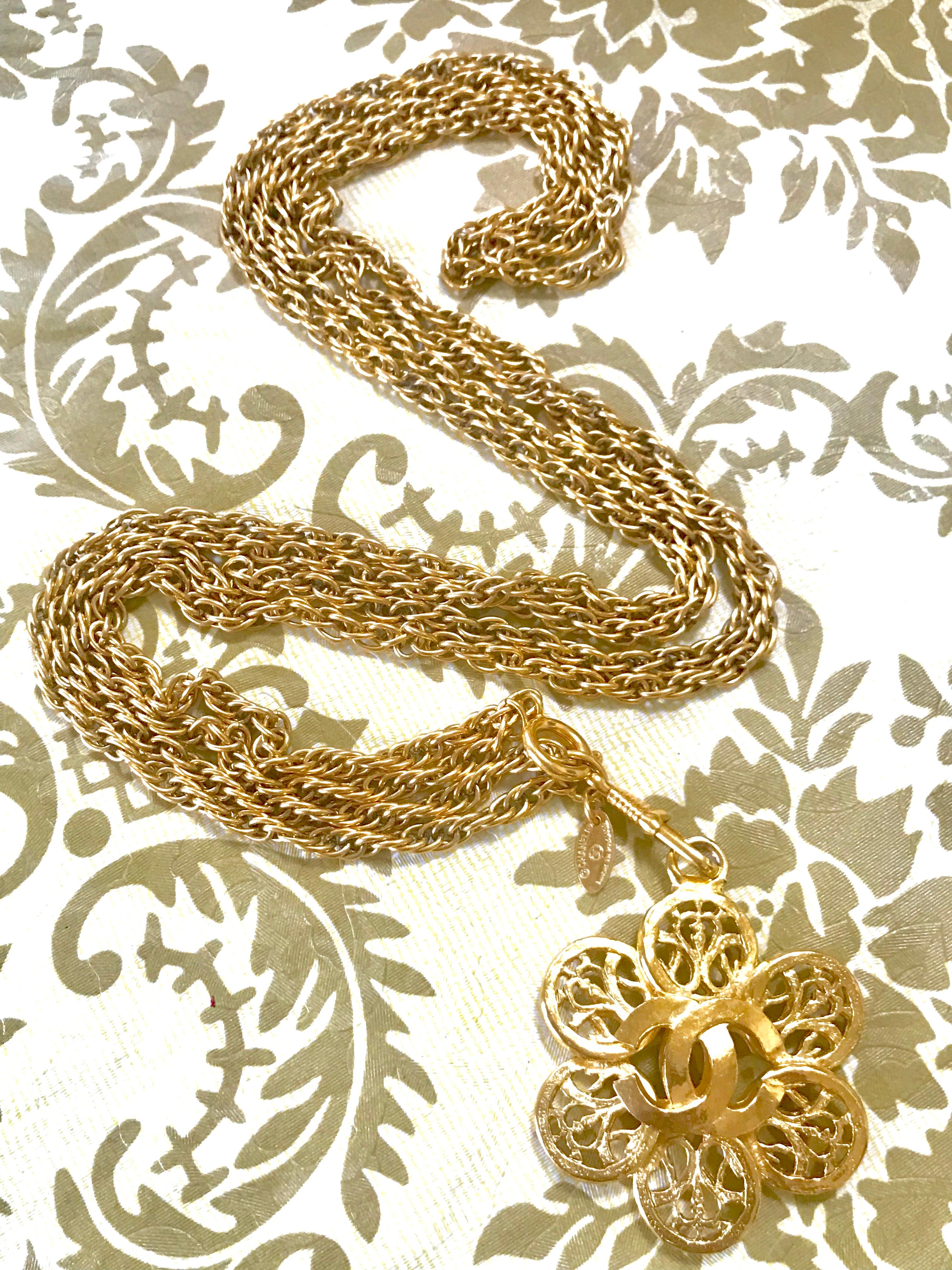 1990s. Vintage CHANEL double golden skinny chain long necklace with arabesque petal flower motif CC pendant top. Classic jewelry.

Introducing a classic and beautiful necklace from CHANEL back in the 90's, golden skinny double chain necklace with