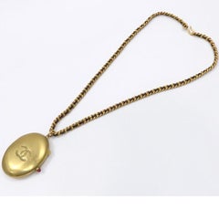 Vintage Chanel pill case design black leather and chain necklace with CC mark.