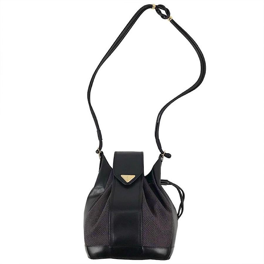 1990s. Vintage Yves Saint Laurent  black hobo bucket shoulder bag with leather trimmings and golden logo plate. YSL classic purse.

Introducing another vintage piece from Yves Saint Laurent, black and purple tone shoulder hobo bucket bag with