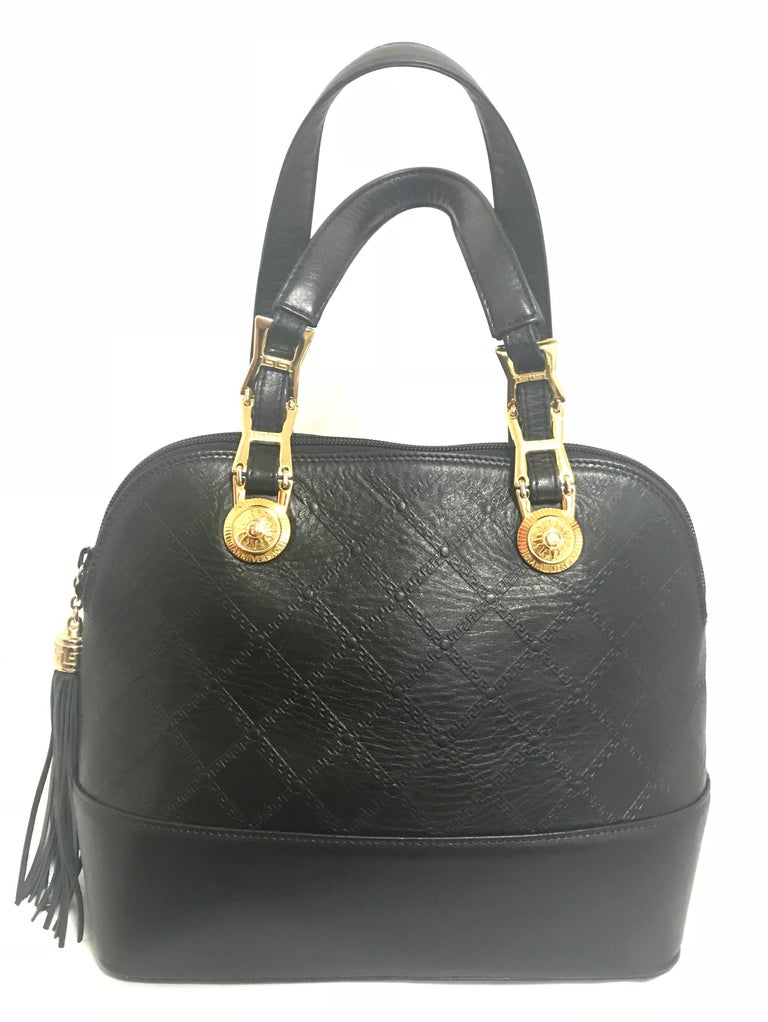 1990s. Vintage Gianni Versace black leather bolide shape handbag with a tassel and golden sunburst logo charms. Lady Gaga style.

Introducing another rare vintage masterpiece from Gianni Versace.
If you are looking for vintage masterpiece from