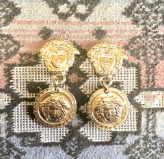 Vintage Gianni Versace gold tone medusa head, face motif dangle earrings.