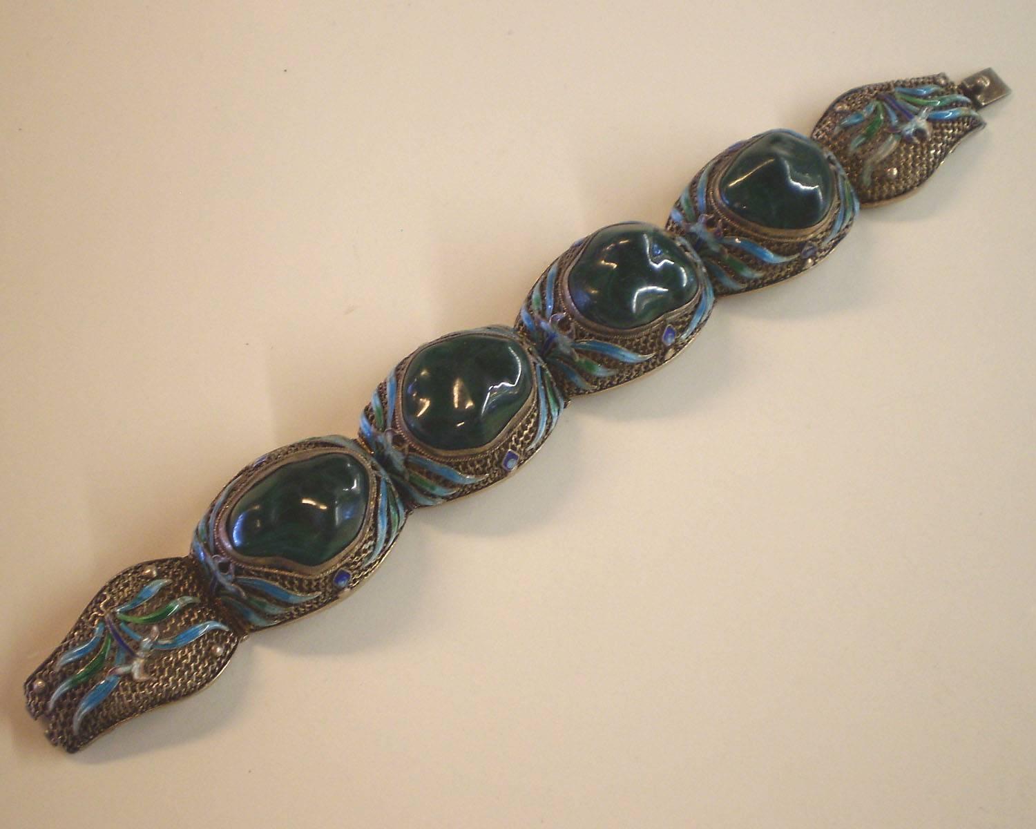 This 1920's sterling silver Chinese link bracelet incorporates time honored techniques of decoration utilized in Chinese art and jewelry of the last several hundred years. The cloisonne enameling is of first quality and the bezel set asymmetrical