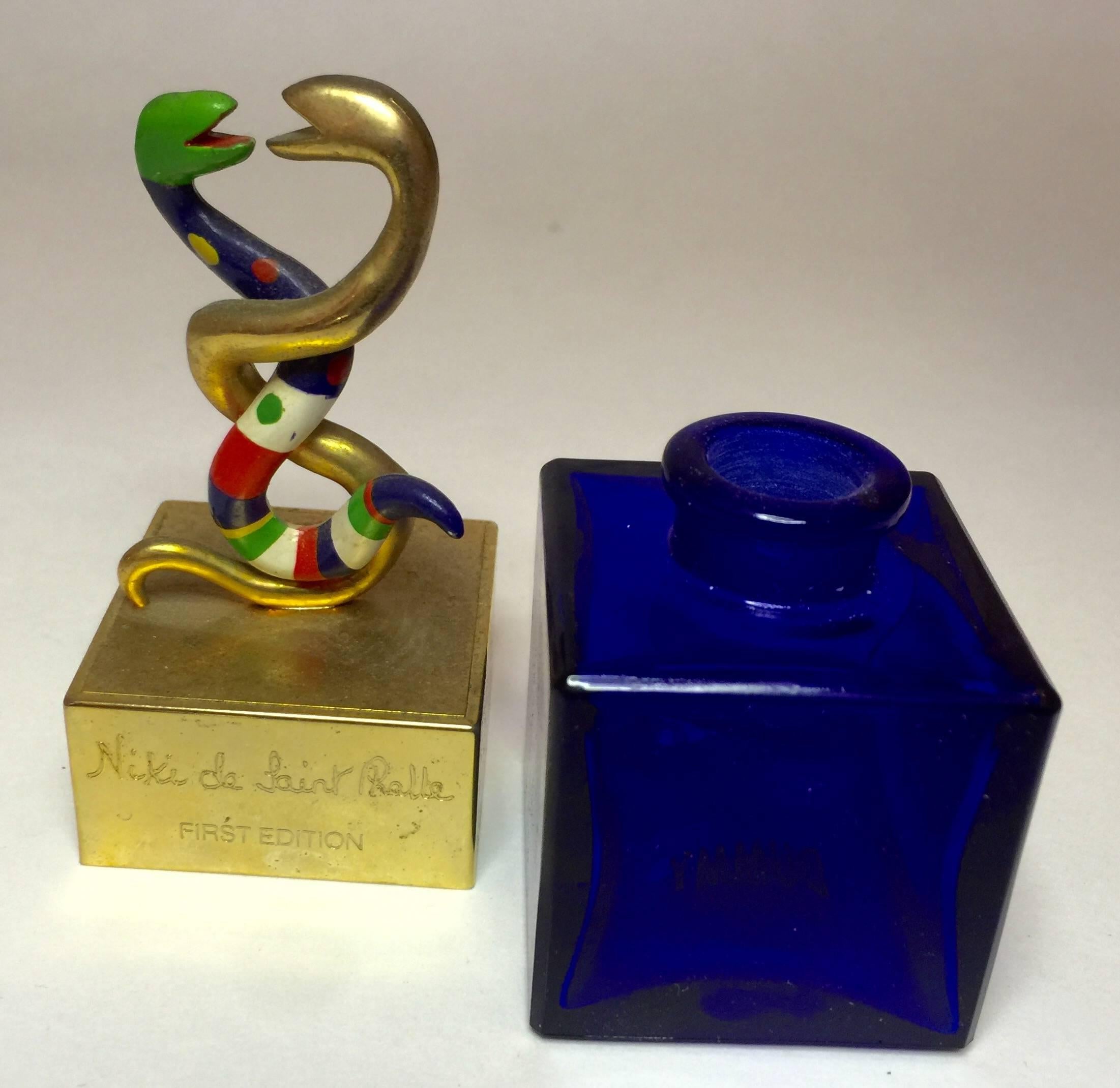 This wonderful iconic 1980's perfume bottle with enameled resin intertwined snakes top and cobalt blue glass square perfume receptacle bottom  is by designer Niki de Saint Phalle. The bottle is empty, and has no perfume contents, box or pamphlet. It