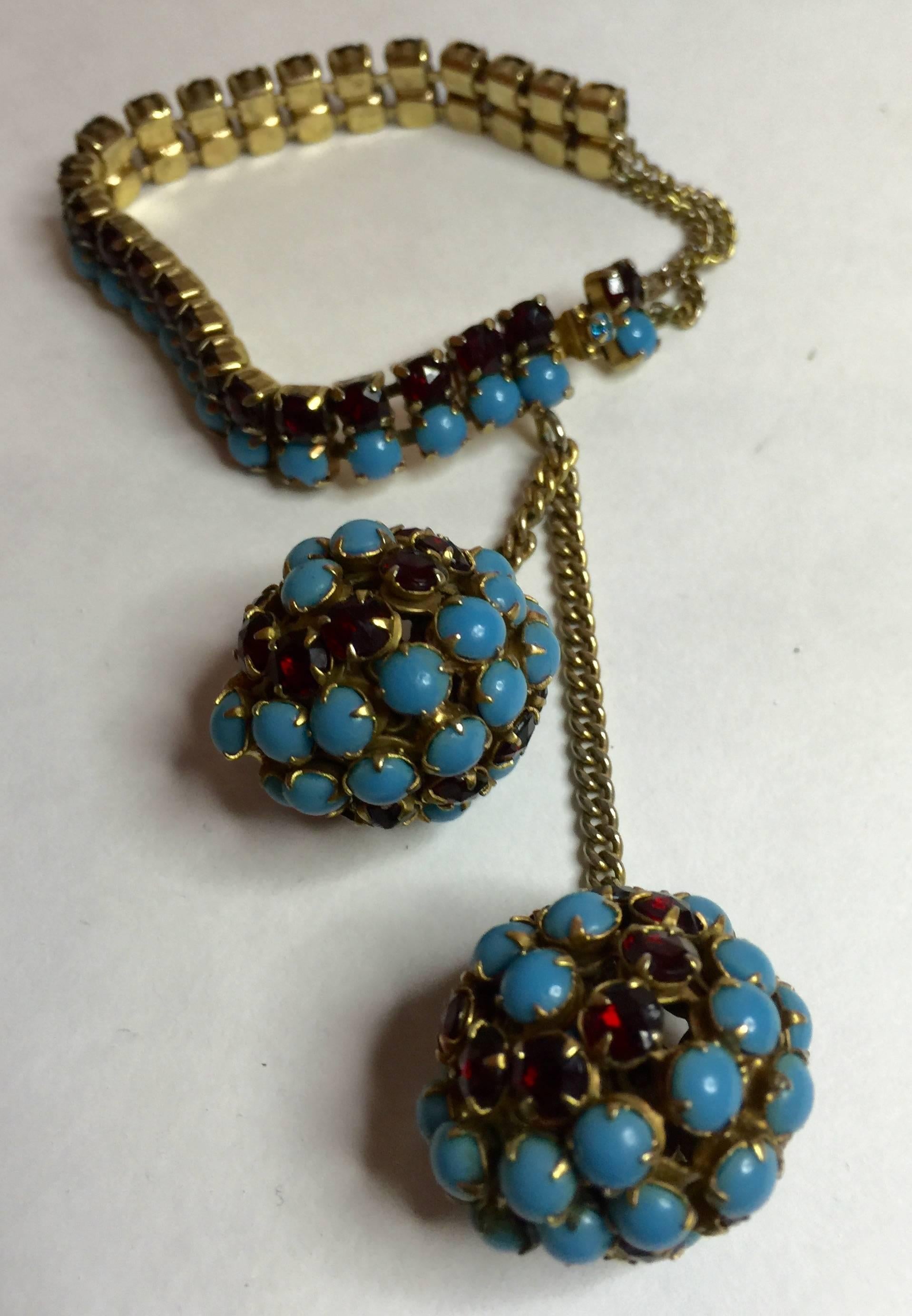 This 1950s HATTIE CARNEGIE Faux Turquoise and Ruby Retro Style Double Ball Drop bracelet is a highly elegant and unusually designed necklace with a classic stone color combination and asymetrical design which is always alluring and appealing. The