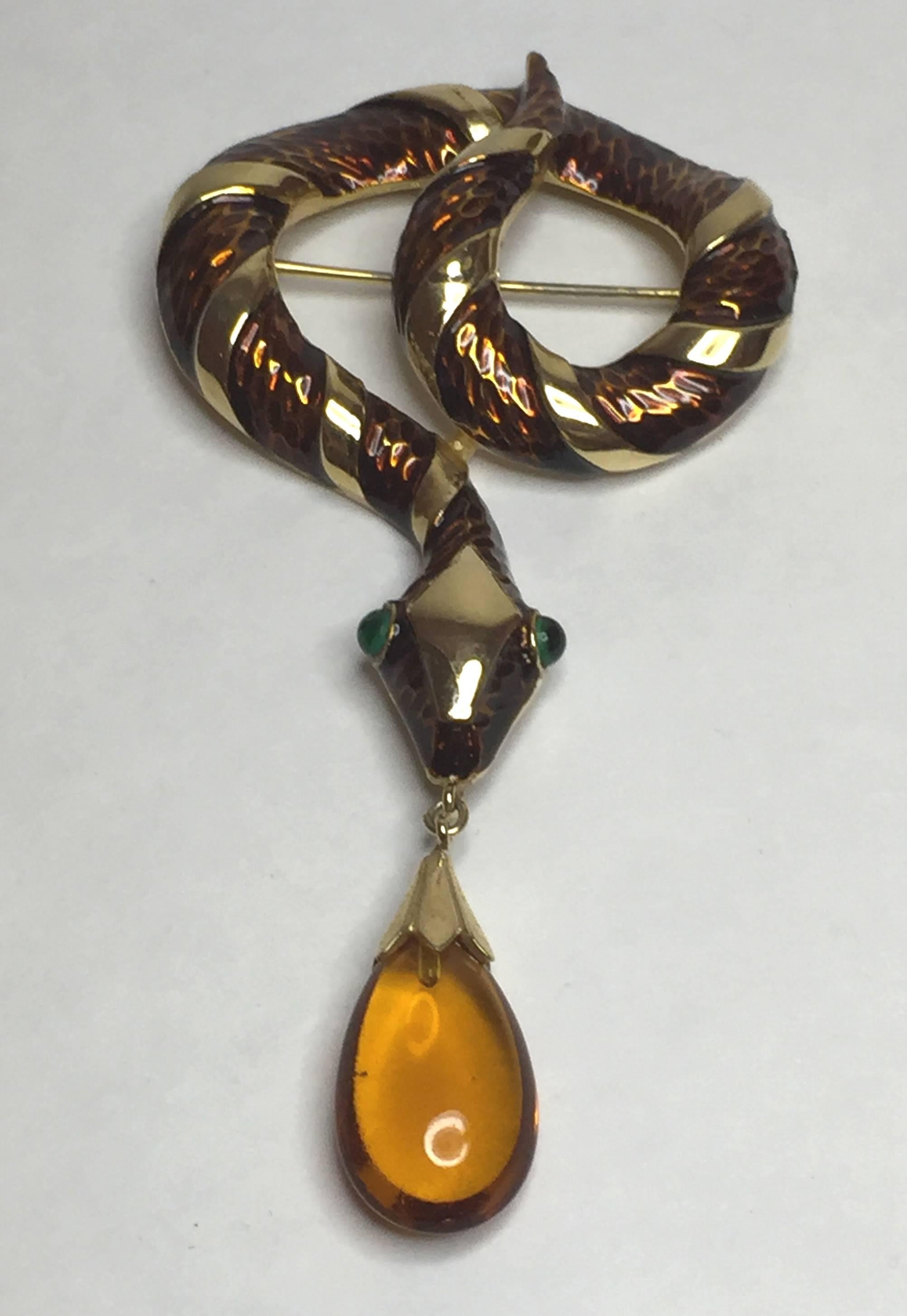 This 1960s TRIFARI Enamel and Brilliant Goldtone Coiled Snake Brooch Pin with Amber Teardrop is exotic and alluring as a figural fashion accessory. The high polish goldtone Trifanium finish is accented by rich glowing enamelling. The intense eyes of