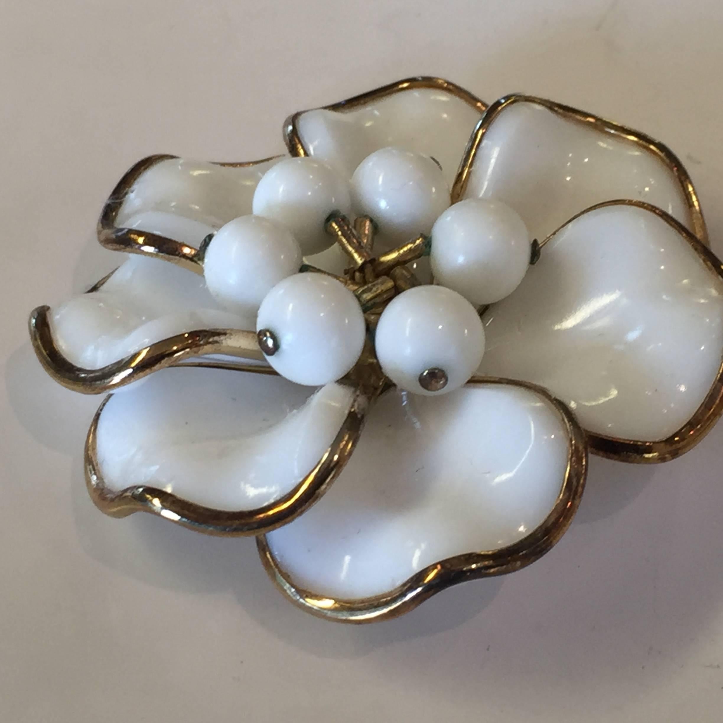 The simple elegance of milk glass is spotlighted in this 1950s TRIFARI Poured Milk Glass Bezel Set Circular Petalled Flower Pin Brooch. Each petal of the flower is individual , and set with a poured milk glass contoured  stone in a pinwheel design,