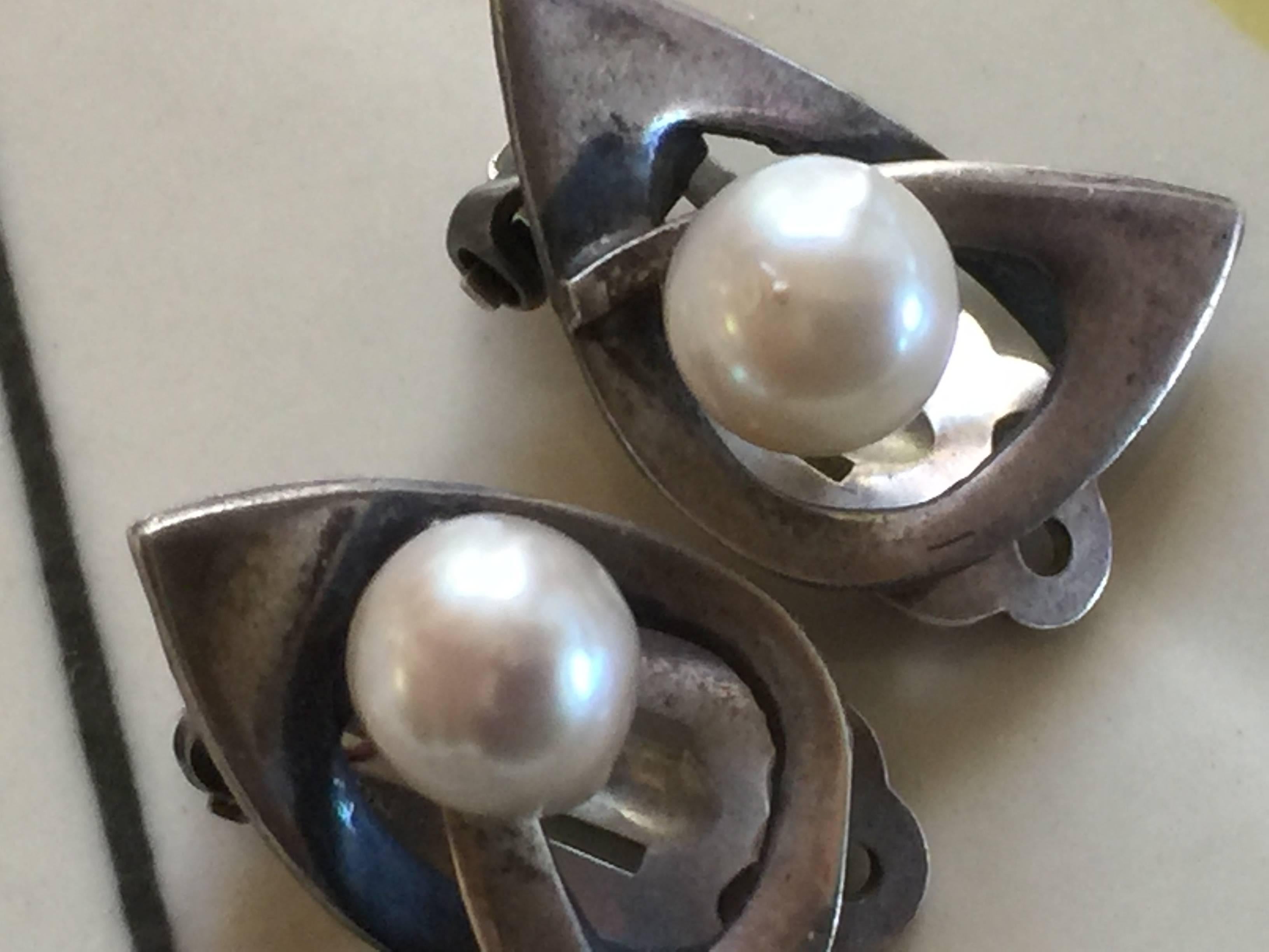 These restrained and classic modernist earrings are by California silversmith esther Lewittes. Marked STERLING and Lewittes, they are silver modernist biomorphs with a large pearl accent and some anodized blackened detail. These have their original