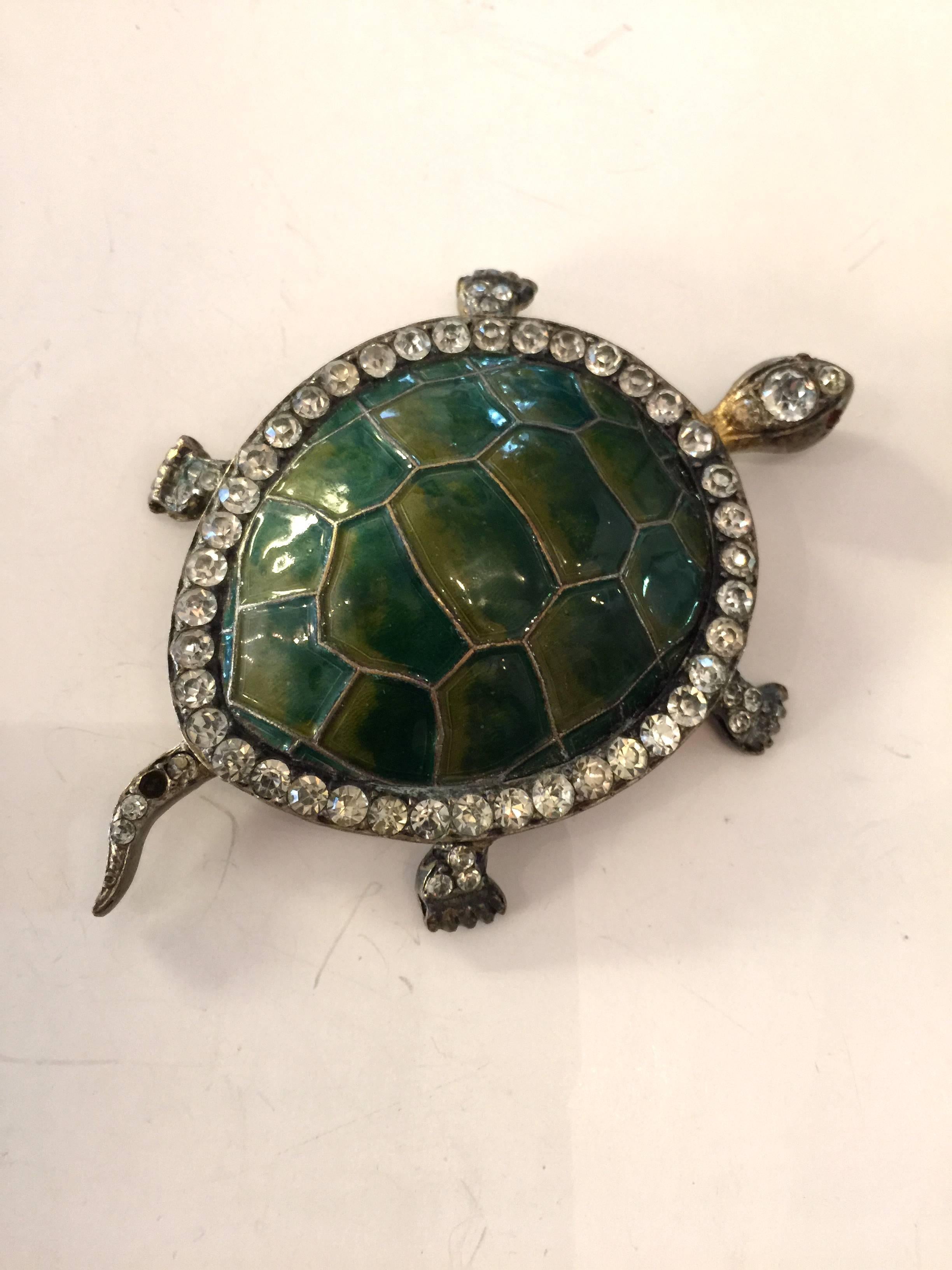 This unusual unsigned turtle pin dates from the 1940s era, and is an unusual hybrid. Its framework is goldtone, and is cast, and then has been encrusted with a border row of white rhinestones and has embellished red rhinestone eyes on this cute