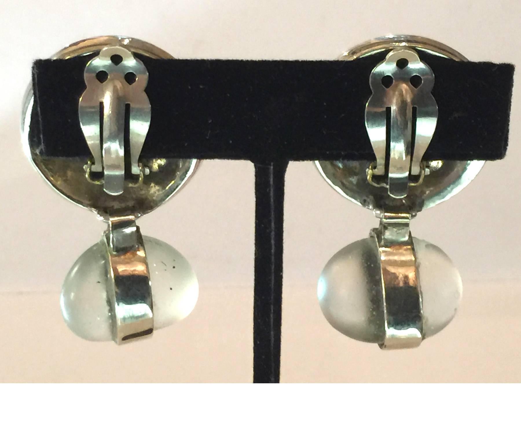 Glamorous, yet simple, these Perez Sanz earrings are of 21st c design and creation, and are from the well known Argentinian manufacture of contemporary glamorous jewels and gems. Silvertone discs with a central rhinestone focal stone suspend