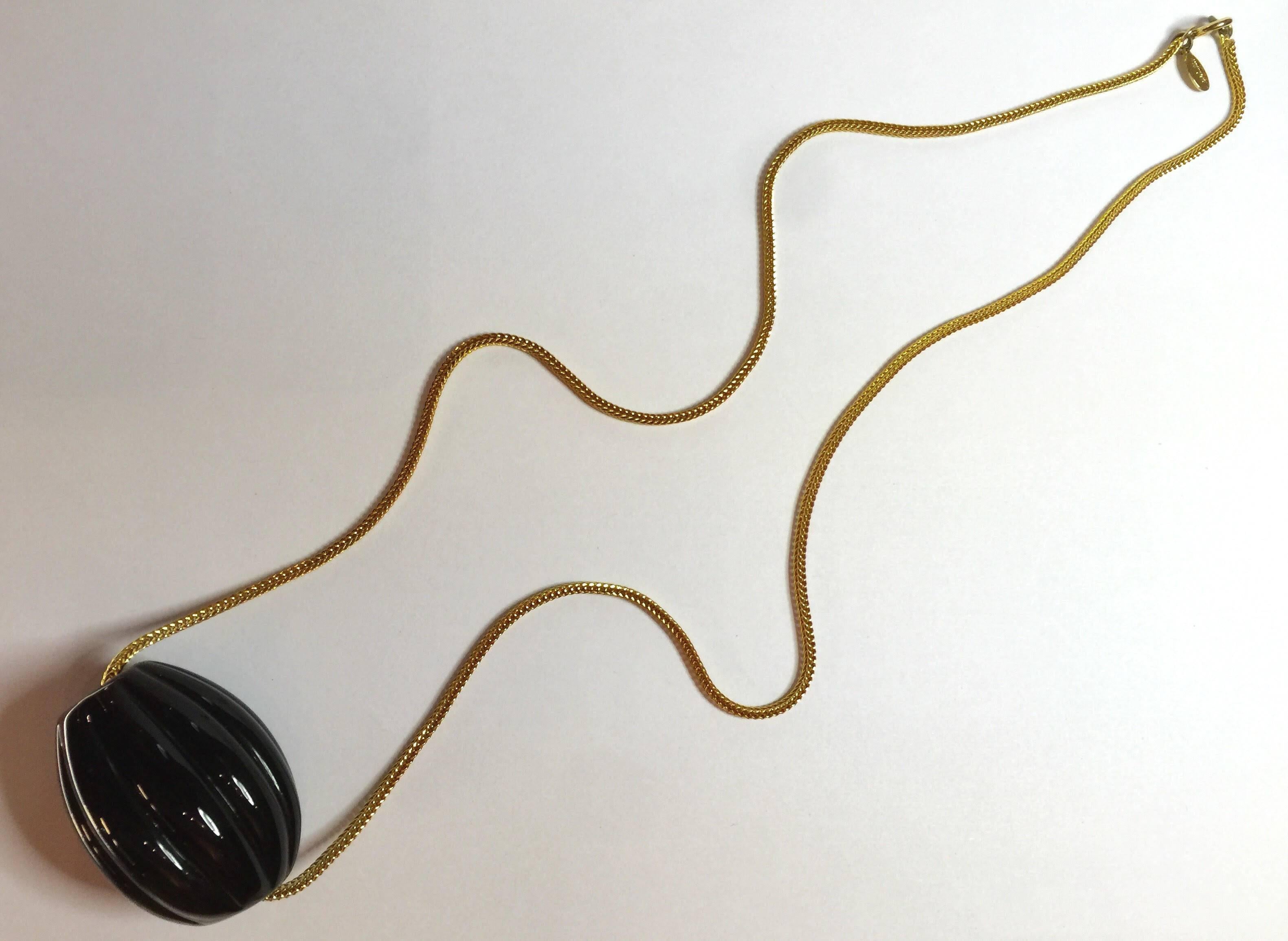 A simple clean lined beautifully designed piece of jewelry, this 1970's William deLillo Modernist Ribbed Black Glass Egg Slide Necklace is utterly reflective of the 1970s era in which it was created. The lovely quality gold tone chain is 26 inches