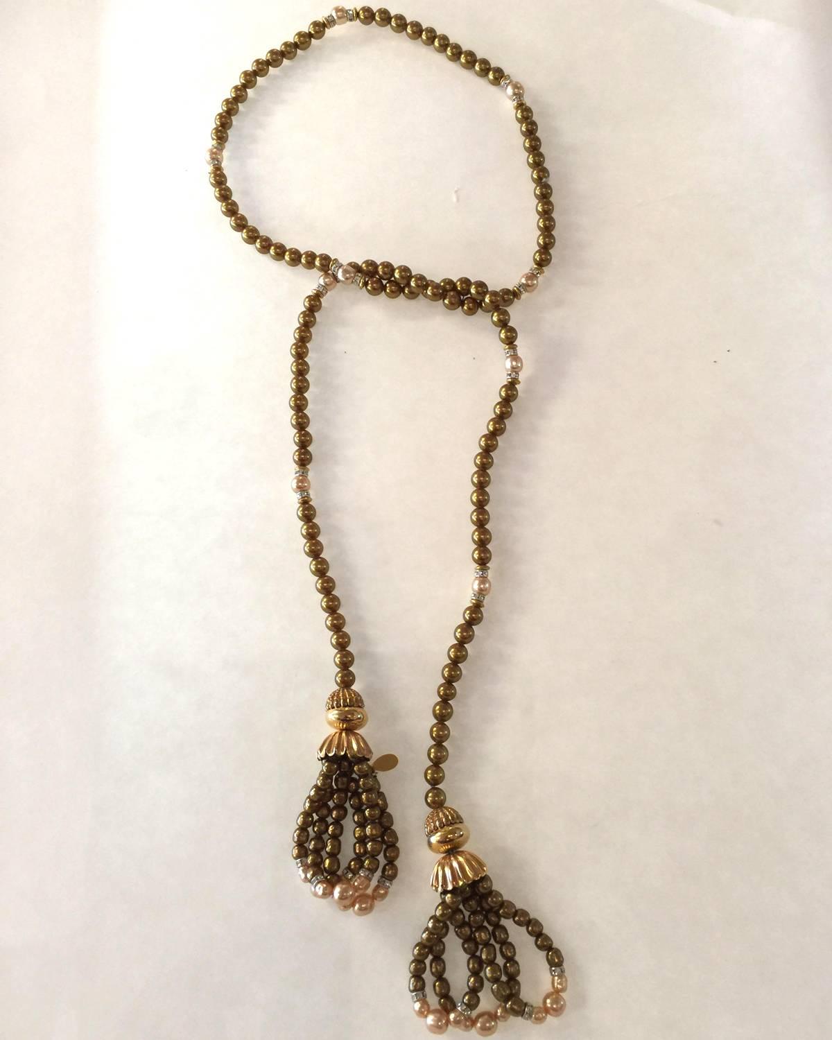 A classic, this 1970s Long Lovely Lariat Necklace by William deLillo is strung Goldtone Beads with  Pearl accents and Rondelle detail ending in looped double tasseled ending. The necklace is 36 inches long and each tassel is 3.5 inches in additional