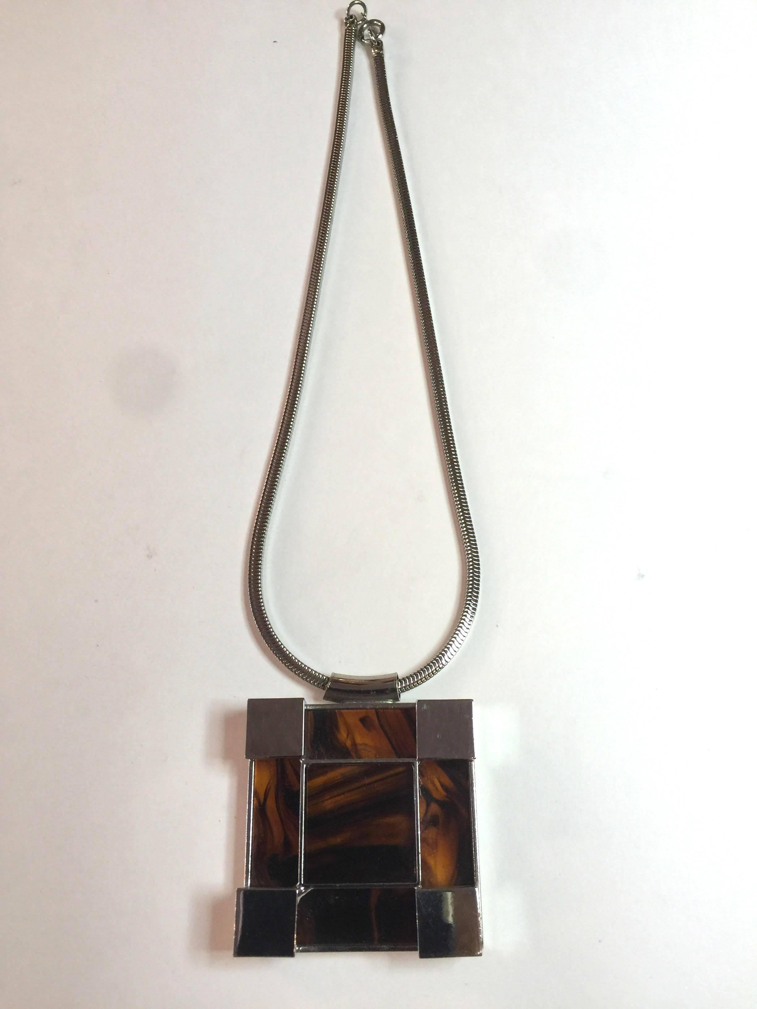 A wonderful unsigned chrome mid century modern square pendant necklace offers a sleek moderne look and certainly could be worn by both women and men. Concentric square detail and design is bold and impactful The square pendant drop is approximately