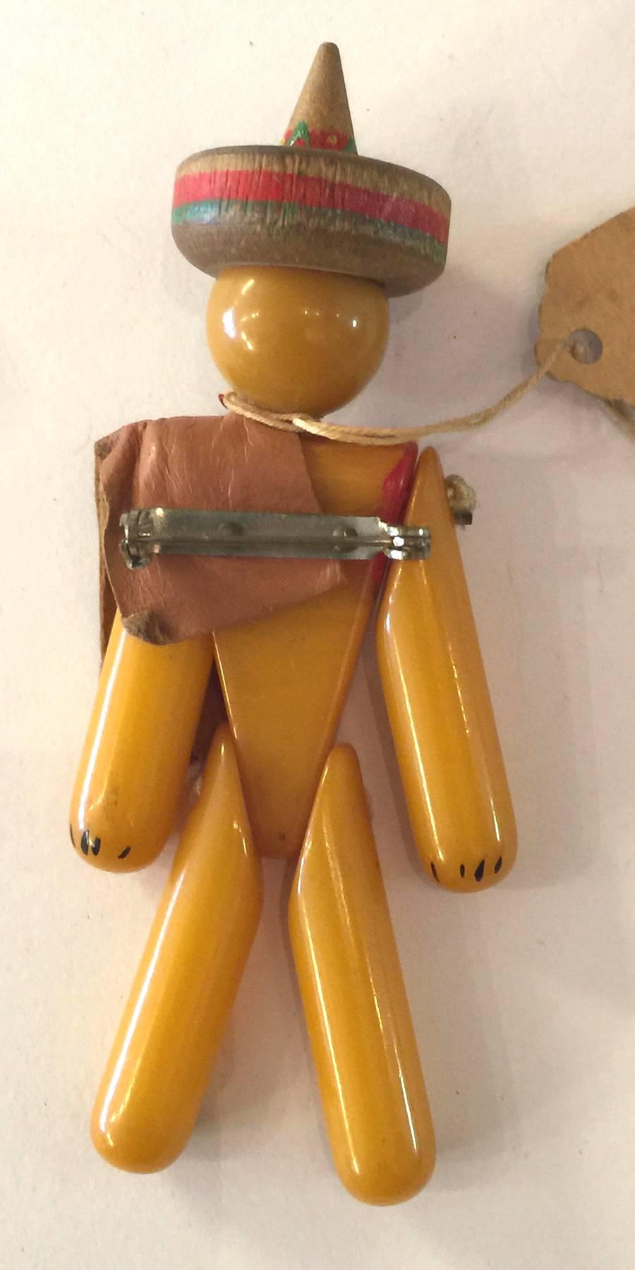 Figural bakelite brooches and pins are always filled with wit and whimsy, and this Mexican Smoking man articulated figure pin certainly delivers on that hope and promise. A combination of bakelite torso, head, arms and legs held together with brass