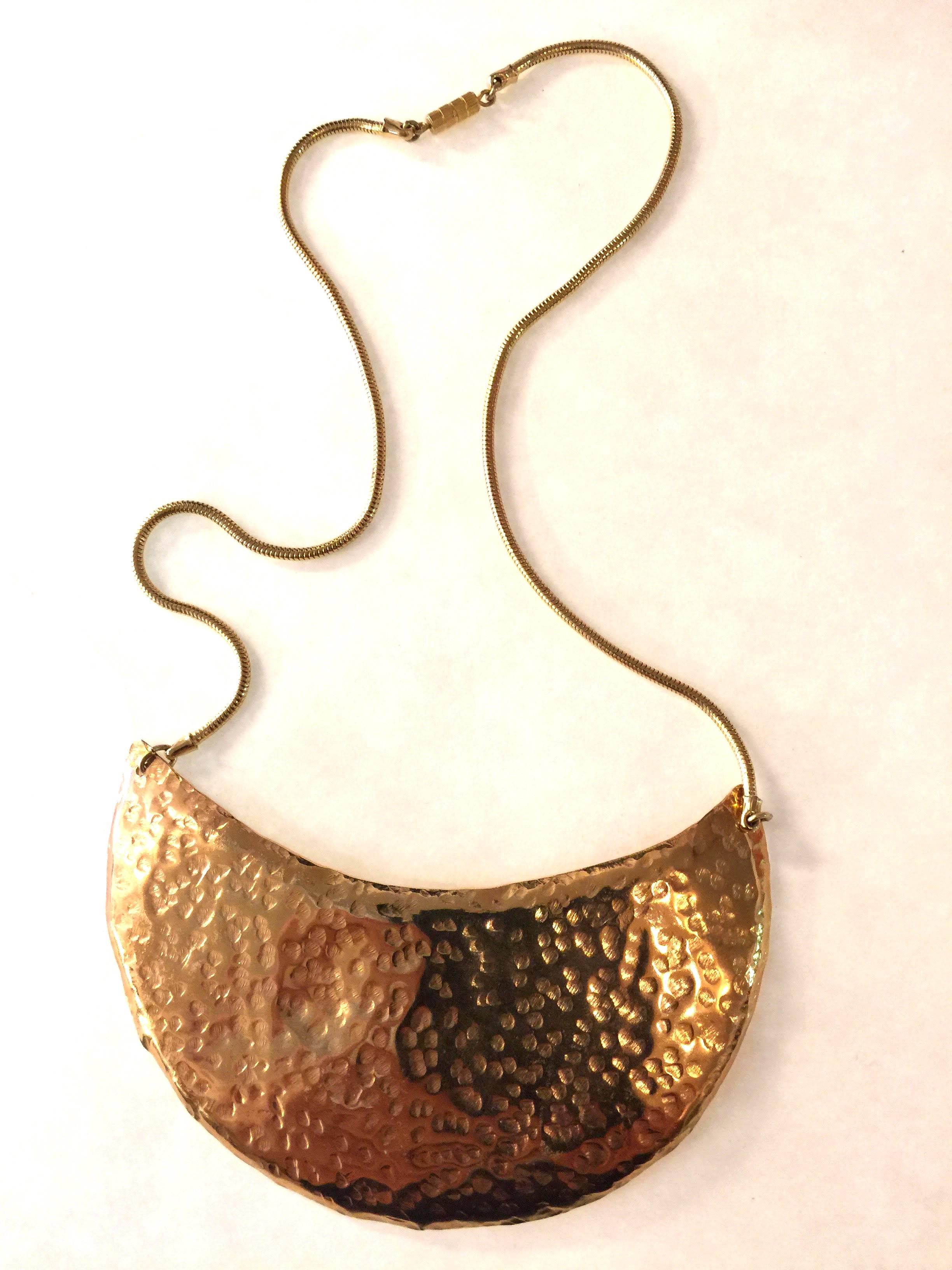 Modern and minimal yet exuding Delillo chic and style, this hammered brass breastplate necklace is 18 inches long and with its 5.5" by 2.5"  semi circular main element achieves a total length of 20 plus inches. Lovely hammered brass has a