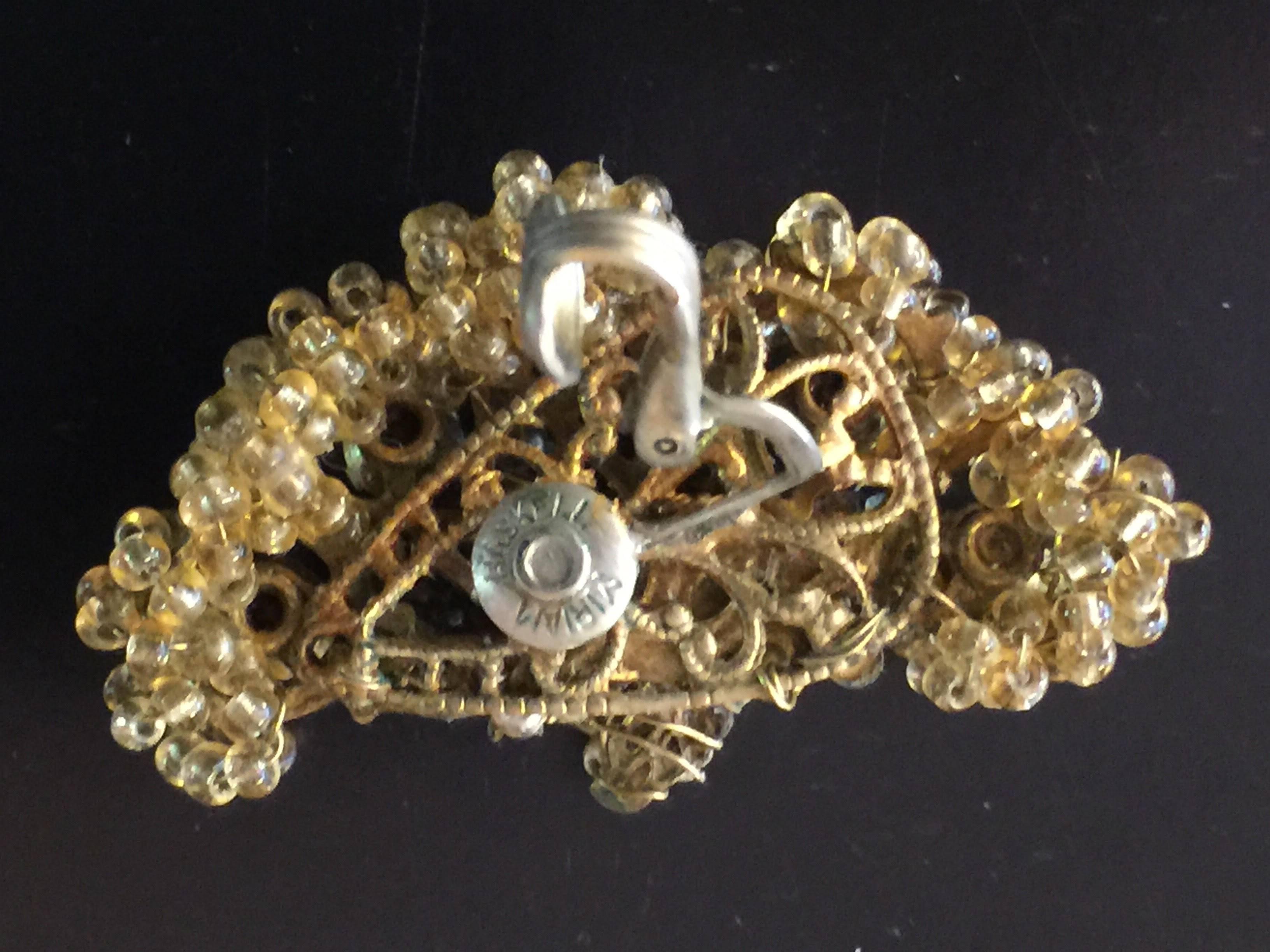 Miriam Haskell always known for intricacy and femininity does not disappoint with these lovely crescent shaped clip earrings on filigree backs with a multitude of brass wired seed peal and seed glass florettes and details, with pearls and