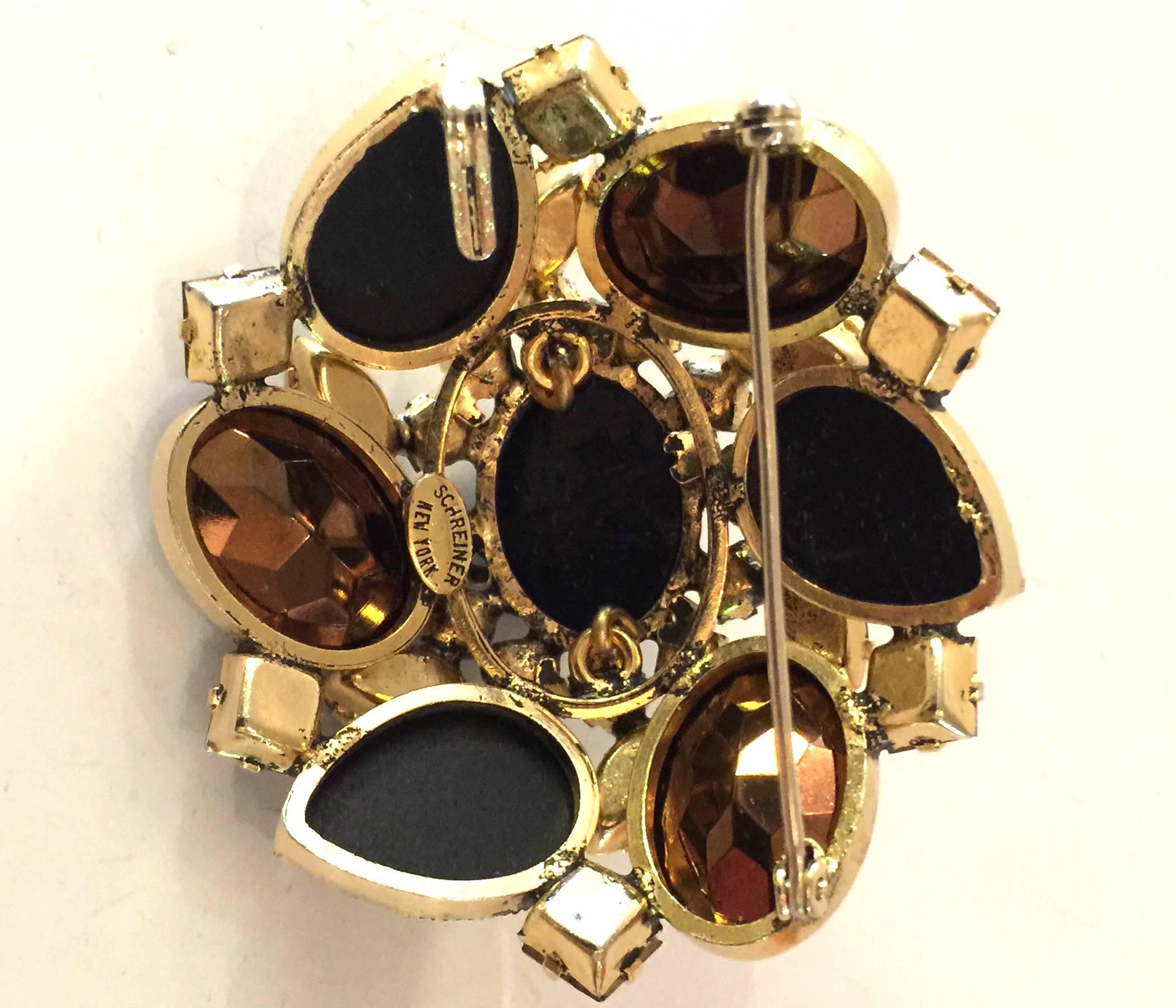 This classic Schreiner New York dome shaped brooch pin pendant is utterly reflective of this makers iconic oeuvre. Known for domed pins and hardware construction utilizing inner oval rings and o ring connectors to build up the height of the pin