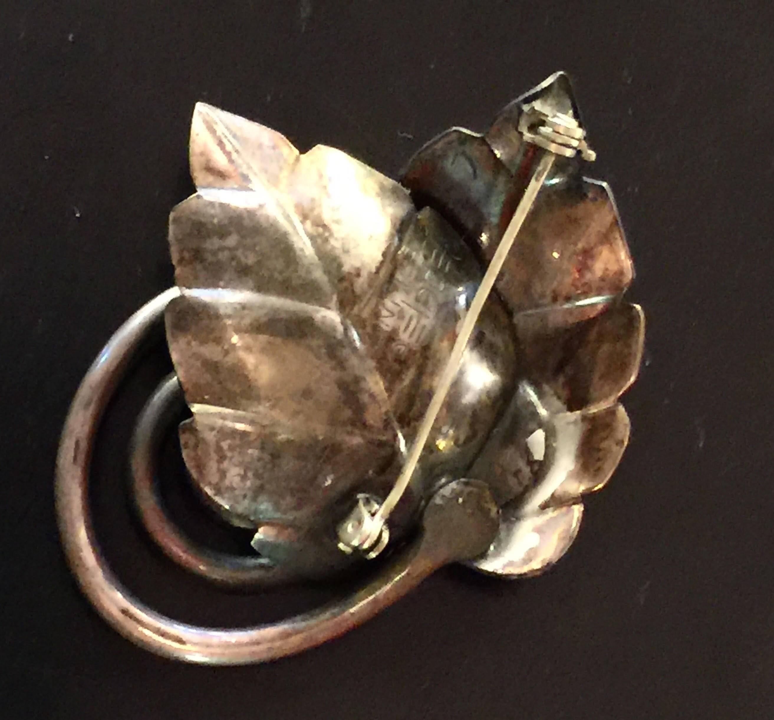 This highly naturalistic coiled stem leaf brooch in sterling silver is by noted Modernist artist Frank Rebajes, The artist worked in both copper and silver and mixed metals too, and this leaf pin has the dimensional and sculptural quality his work