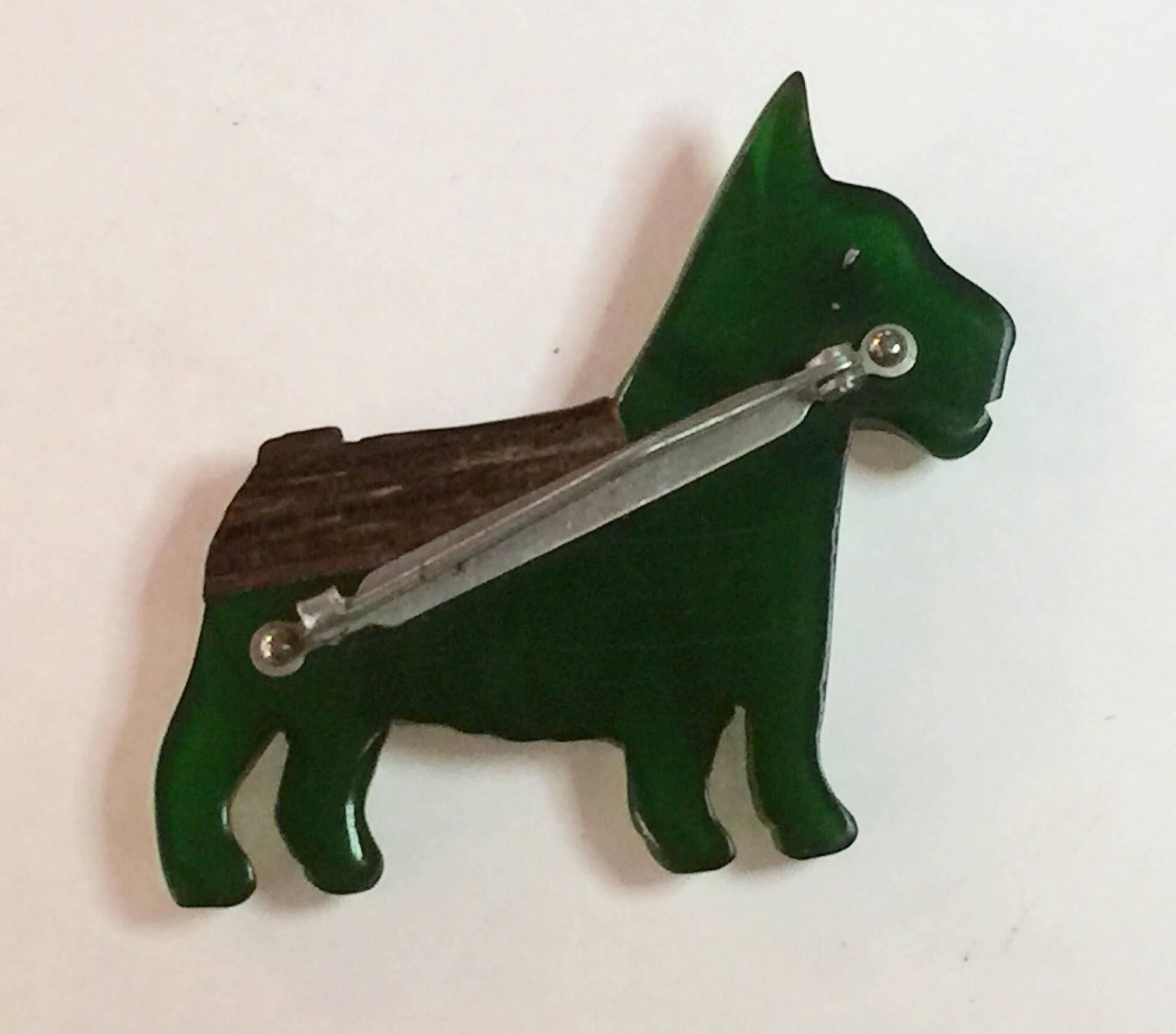 Another canine creation offered here is this GREEN Bakelite and Laminated Wood Terrier Dog Pin Brooch, also classically 1930s and very much representative of the whimsicality of bakelite figural animal pins. 2.25