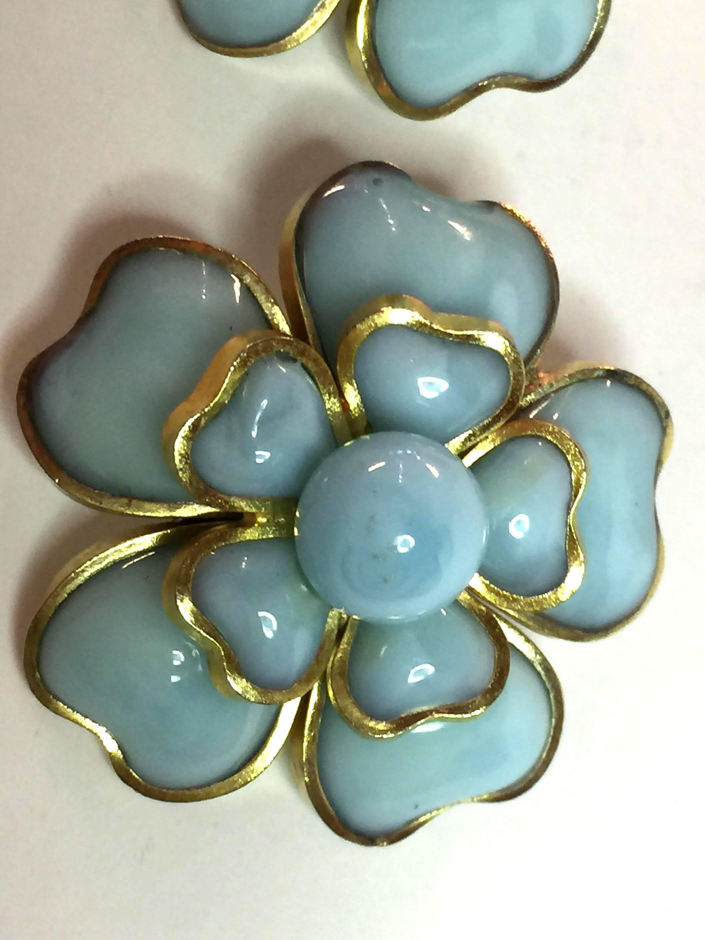 These are luscious  pale blue poured glass earrings made with storied GRIPOIX French heart shaped gilt bezel set stones of glass. Their combination creates a large and lovely flower form clip earring approximately 1.2 " in diameter with