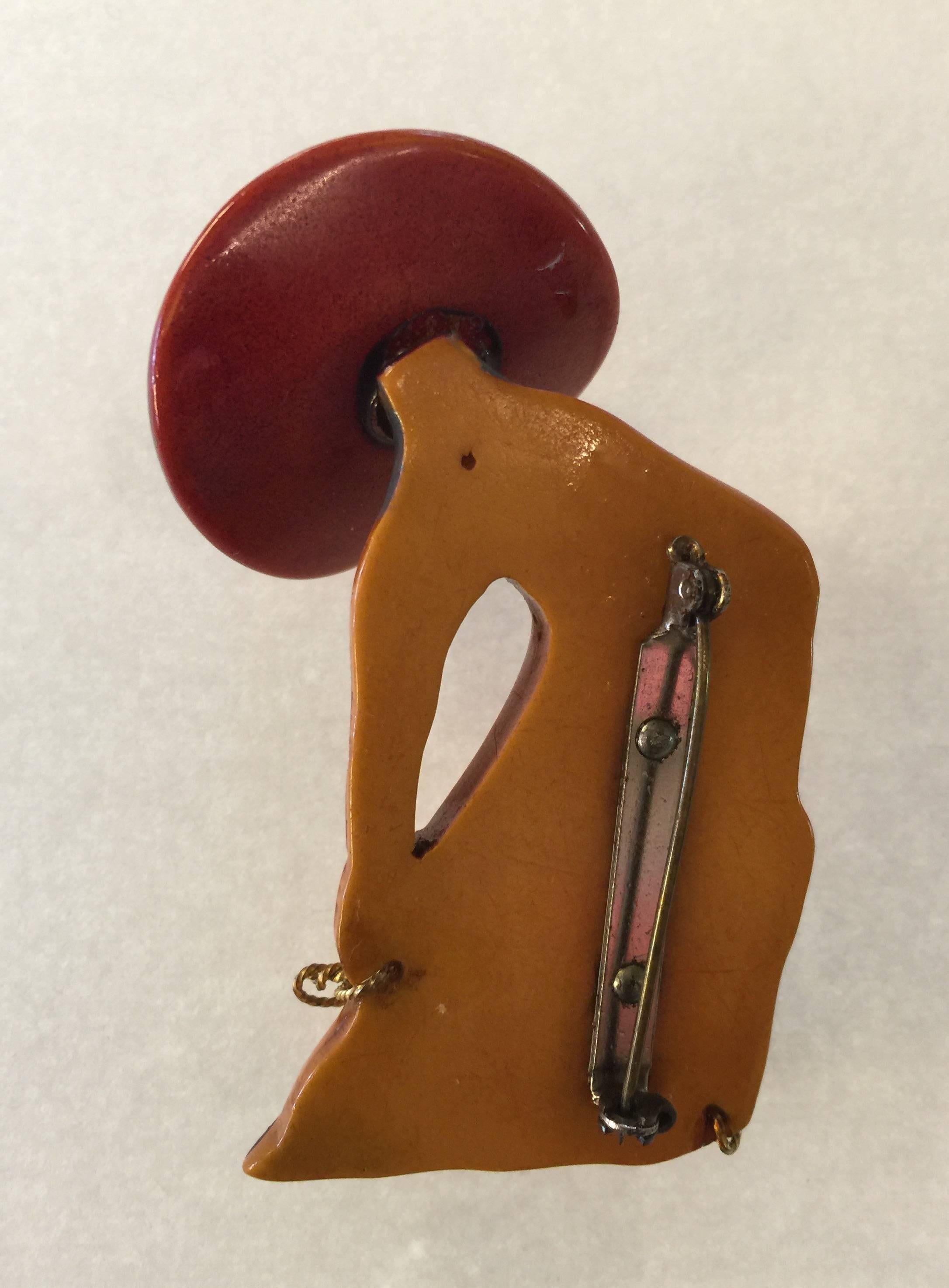 A beautiful and amusing bakelite cowboy pin with painted detail, resin washed large three-dimensional hat over face and brass coiled lariat detailing., The body of the cowboy is not resin washed but the hat is. 1930's Americana makes this bakelite
