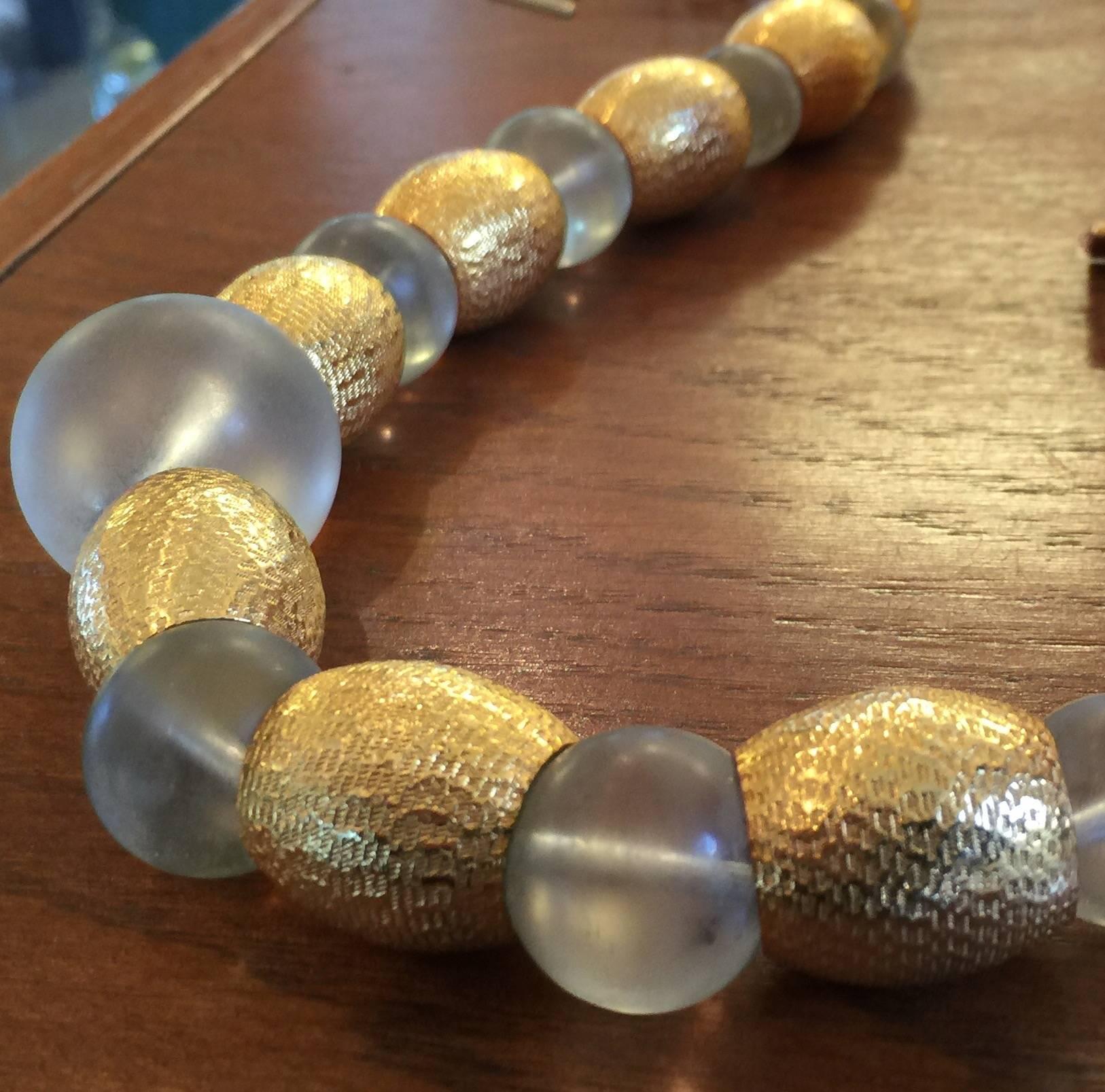 This wonderful 1970's necklace singed by master designer PIERRE CARDIN is both glamorous and modernist in tone, Graduated frosted acrylic spheres and flattened spheres alternate with hammered graduated goldtone barrell shaped beads to create a