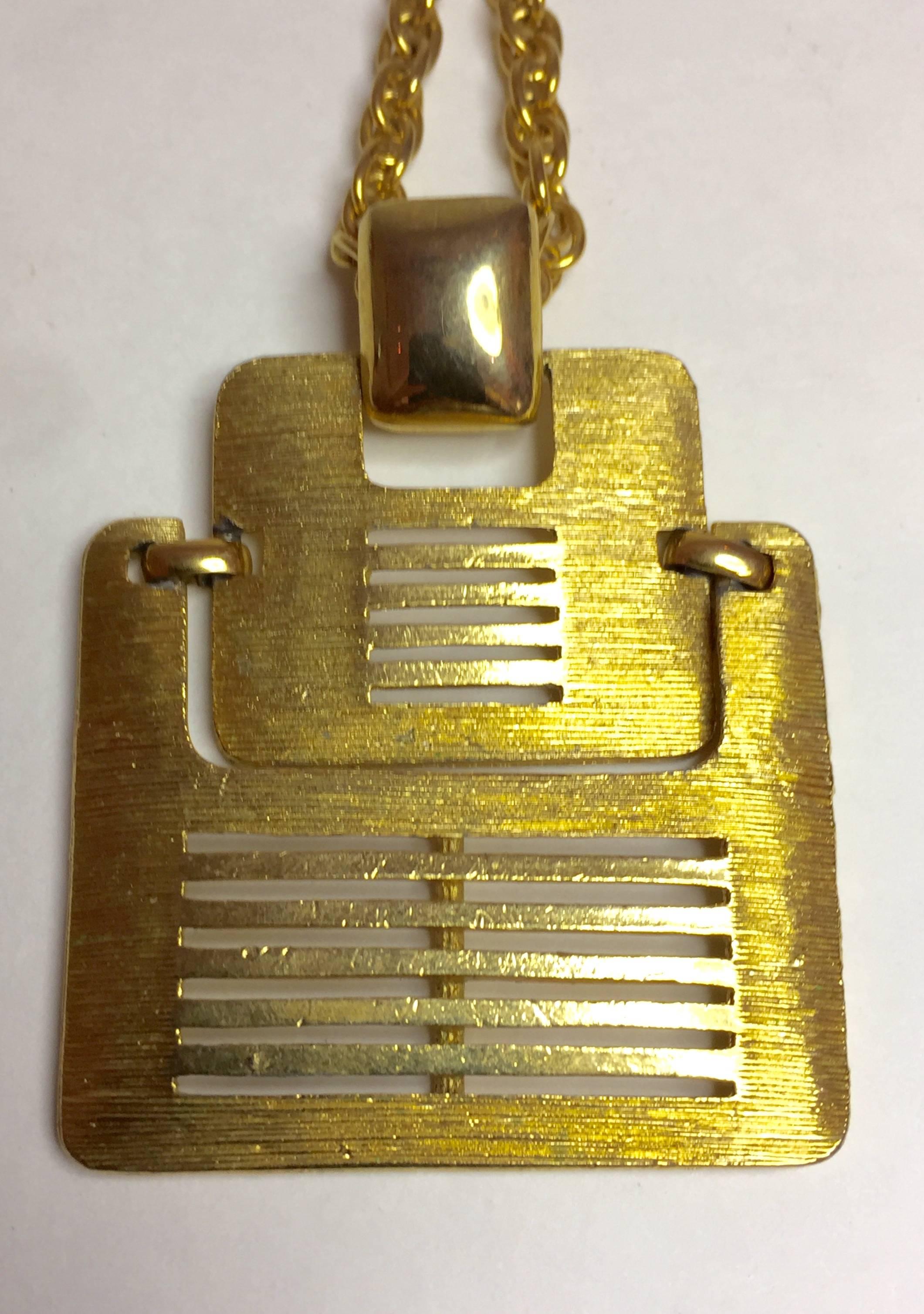 An unsigned beauty, this 1960s Brushed Goldtone Mid Century Modern Two piece Pendant Necklace on Chain, has louvered horizontal slats and a pivoting mid section allowing for movement while being worn.  Although unsigned, it ressembles TRIFARI and