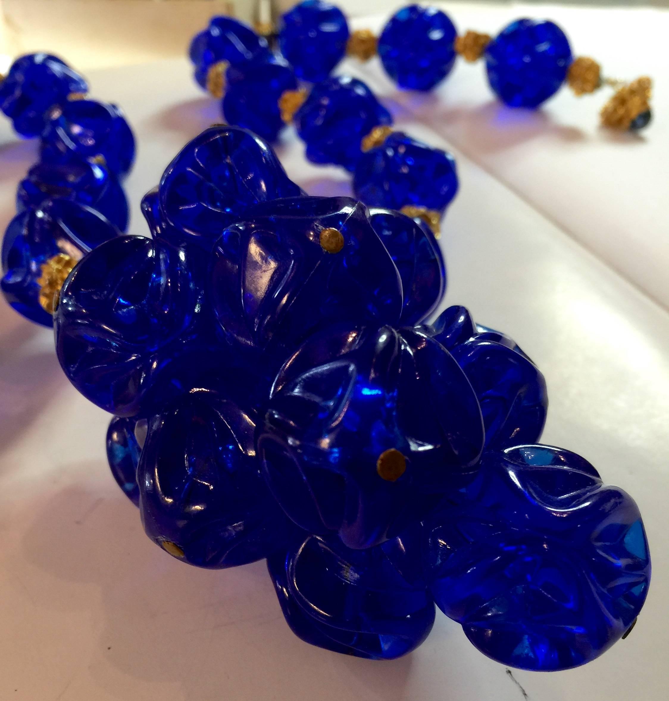 This  1970s William deLillo Amazing Electric Blue Resin Grape Cluster Necklace is highly unusual in color and execution. The resin molded beads are melon bead like in form, but much larger and more dramatic. There are brutalist figured goldtone
