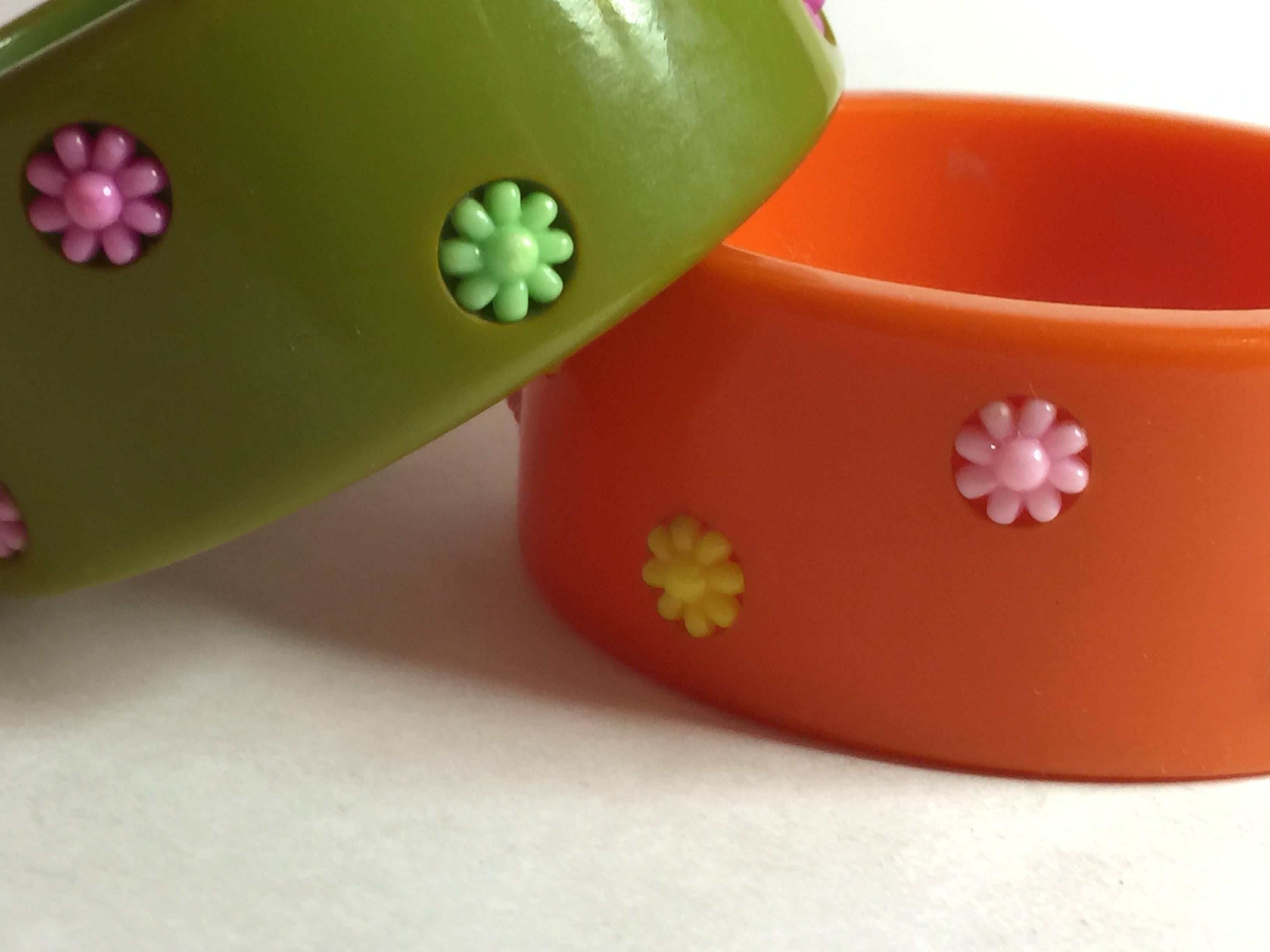 This super-fun 1930s Art Deco Geometric Dotted Inlaid  pair of Bakelite bangles in  Orange and Green, with lighter thermoplastic multicolored asterisj shaped dot inserts...in a variety of colors on each,  Its ironic that these late deco items from
