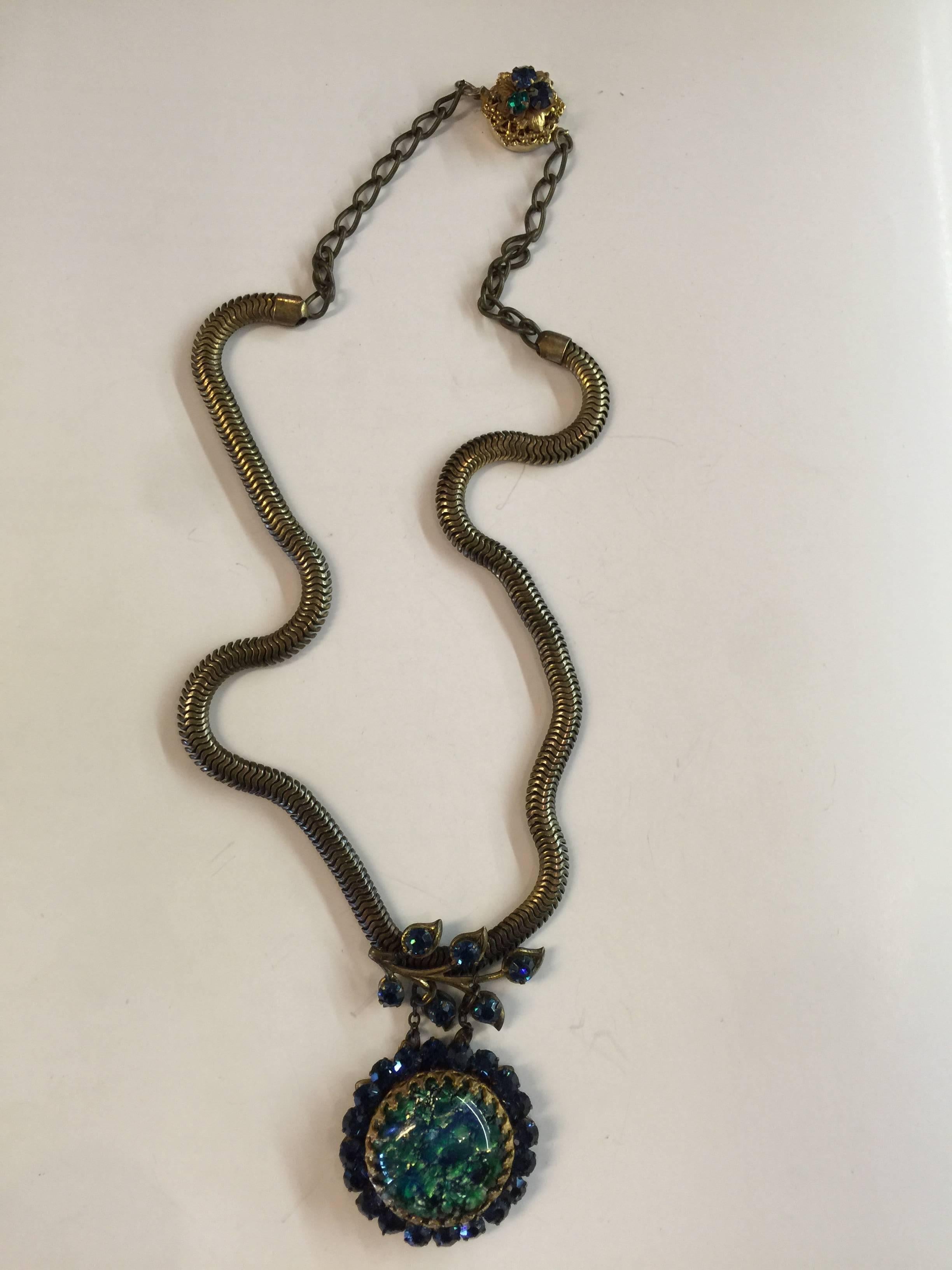 This unusual 1950s MIRIAM HASKELL Slinky Chain Necklace with blue stone and blue rhinestone rhinestone drop is not typical of the storied company's usual work style. Antiqued gold flat chain is super-tailored in appearance, and the lovely domed