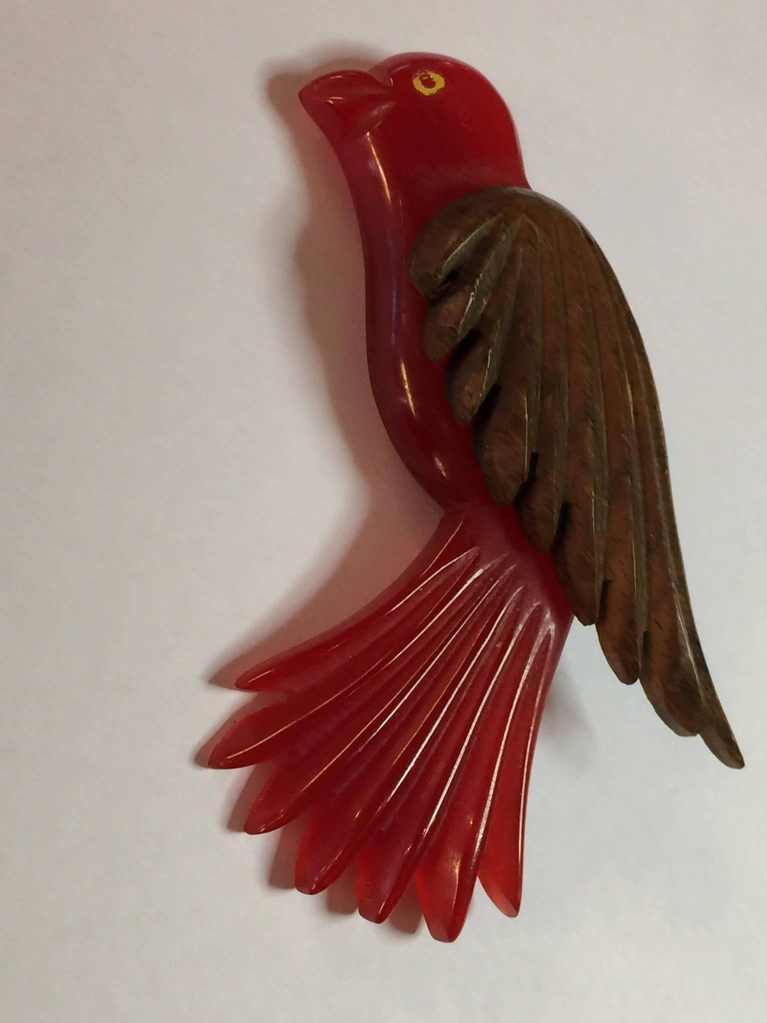 This fine example of the bakelite carver's art is actually a combination of bakelite and wood grommeted together: always a sporty and kicky combination! 1930s in origin, these wood laminated pins always showed off finesse and detail of carving, as