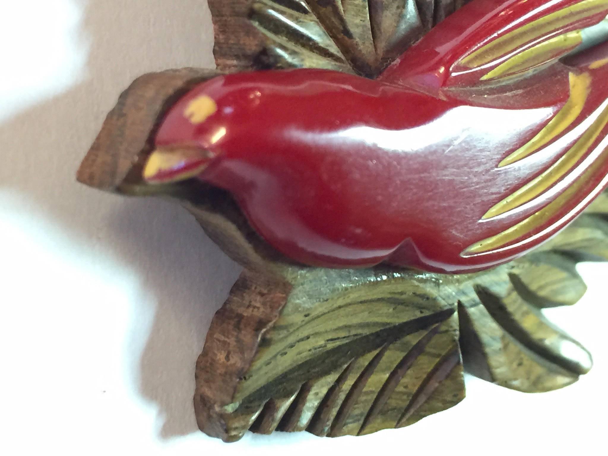 This fine example of the bakelite carver's art is actually a combination of bakelite and wood grommeted together: always a sporty and kicky combination! 1930s in origin, these wood laminated pins always showed off finesse and detail of carving, as