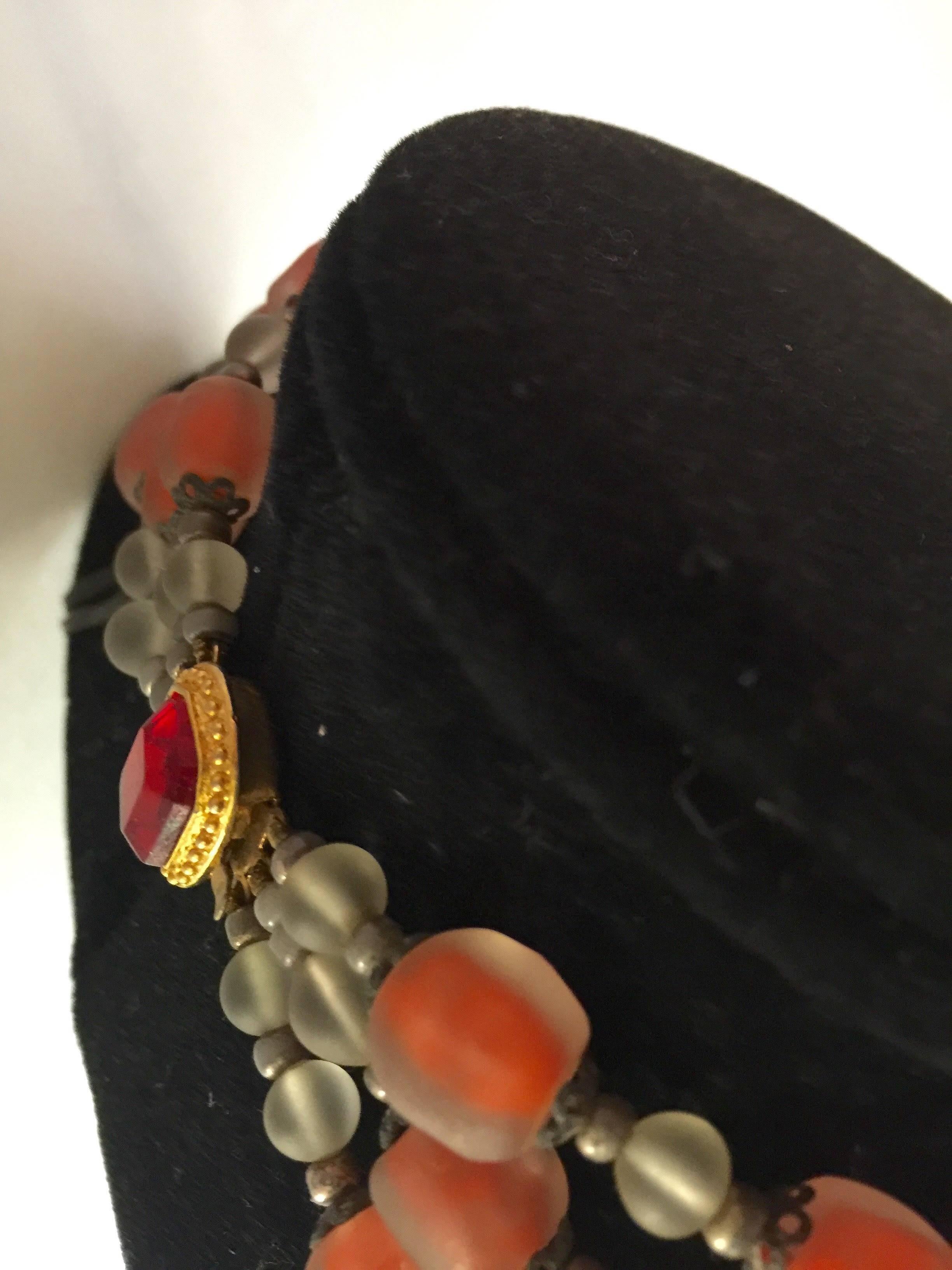 This 1960s Italian Frosted and Cased Glass Beaded Triple Strand Necklace is the result of the glass blowers art turned focus on the world of jewelry and beadmaking. These lusciously brilliant orange cased glass beads are tumbled and frosted for an