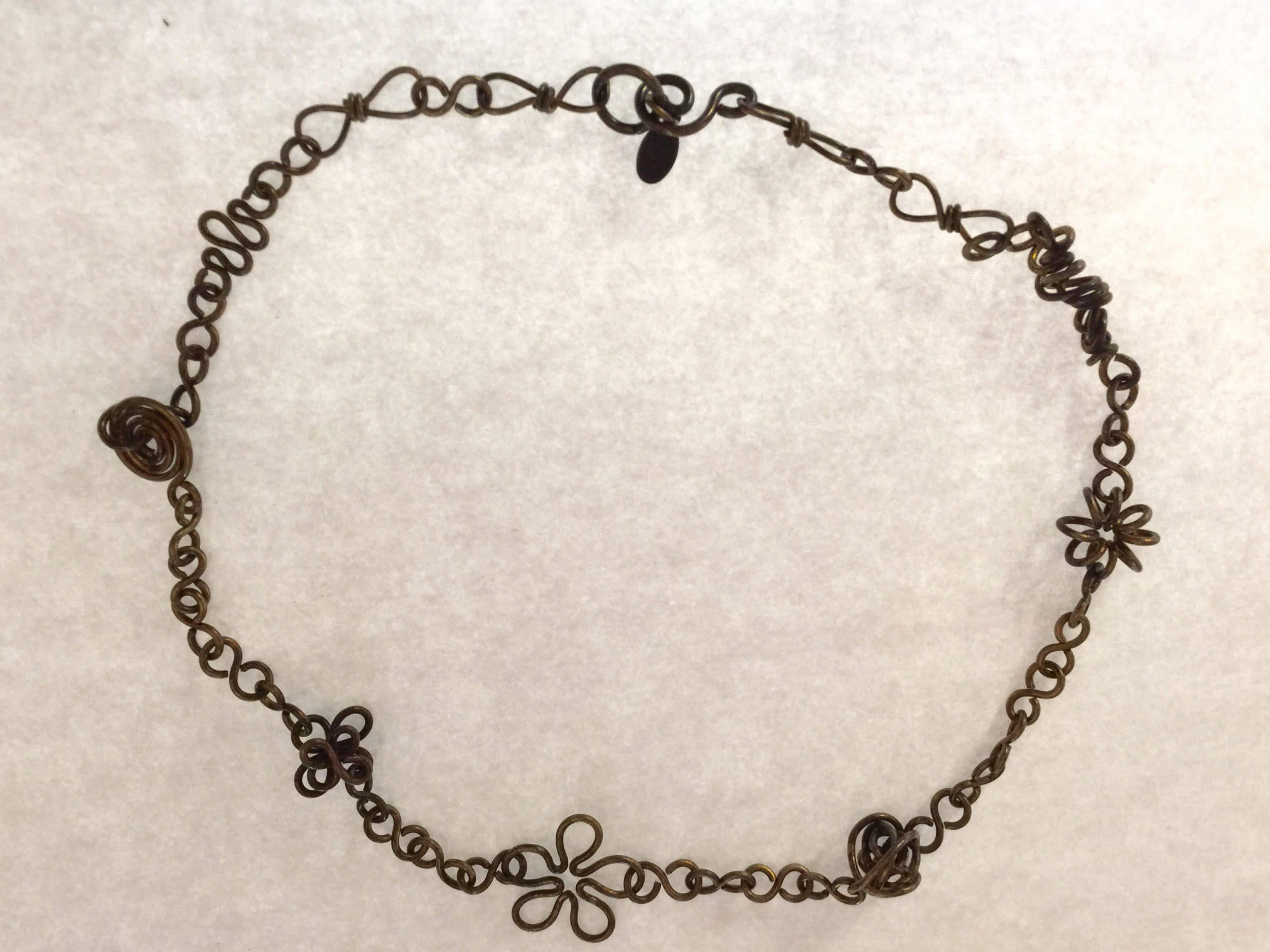 This 1980s Martha Sturdy Bronze Coiled Modernist Flower Necklace is simply superlative. Dainty and small in scale, this bent bronze wire necklace is super clean lined and modernist in tone and intent. 18" long. Modernist sputnik like balls are
