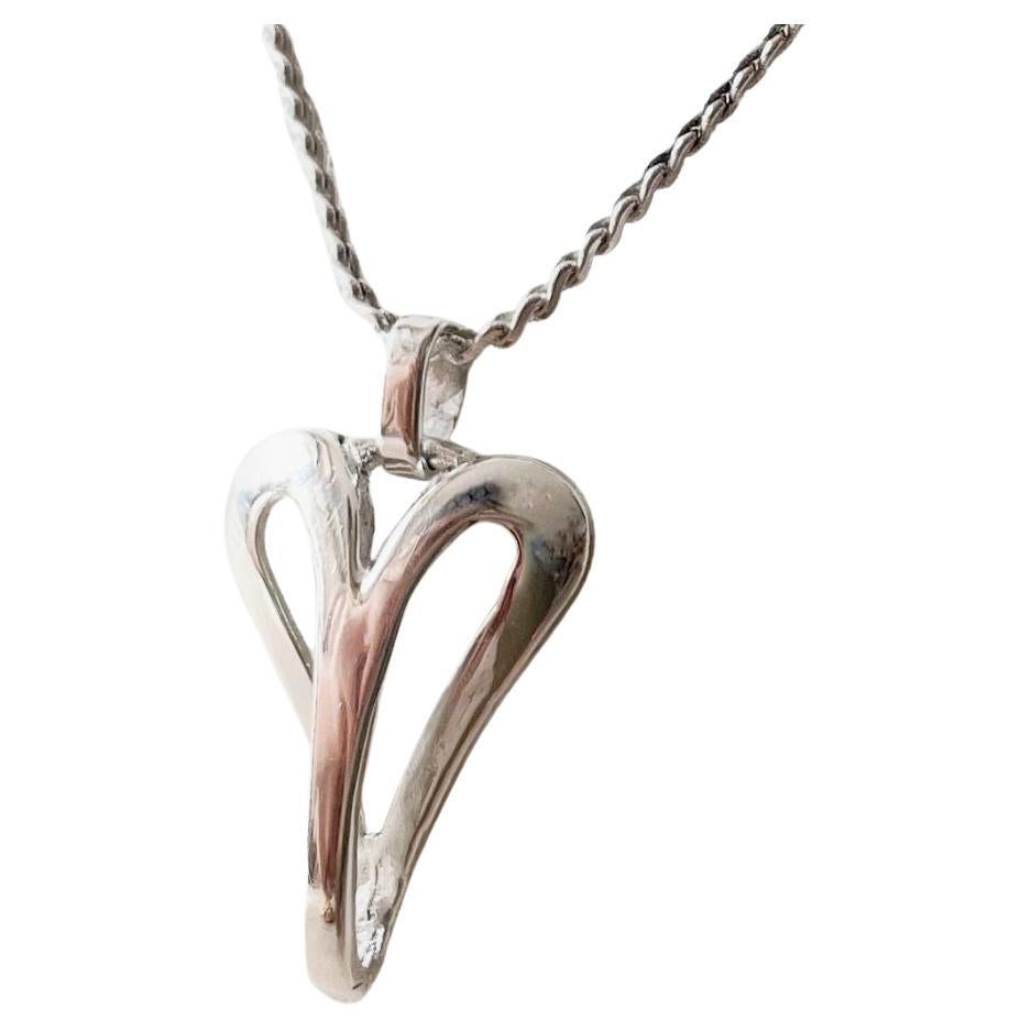Eleganza senza tempo con la Collana Cuore, un bellissimo pezzo realizzato a mano in argento 925. Caratterizzata da una delicata catena fine e da un piccolo ciondolo a forma di cuore dai dettagli intricati, questa collana è un simbolo di amore e