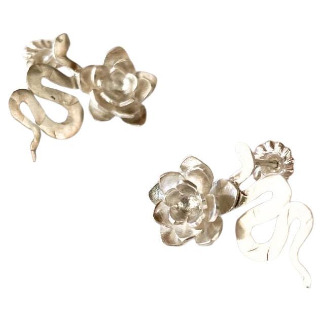 Realizzati meticolosamente a mano in argento 925, questi orecchini con serpente e fiore fondono due simboli potenti: il serpente, che rappresenta la trasformazione e la rinascita, e il fiore, emblema senza tempo di bellezza e crescita.

Il loro