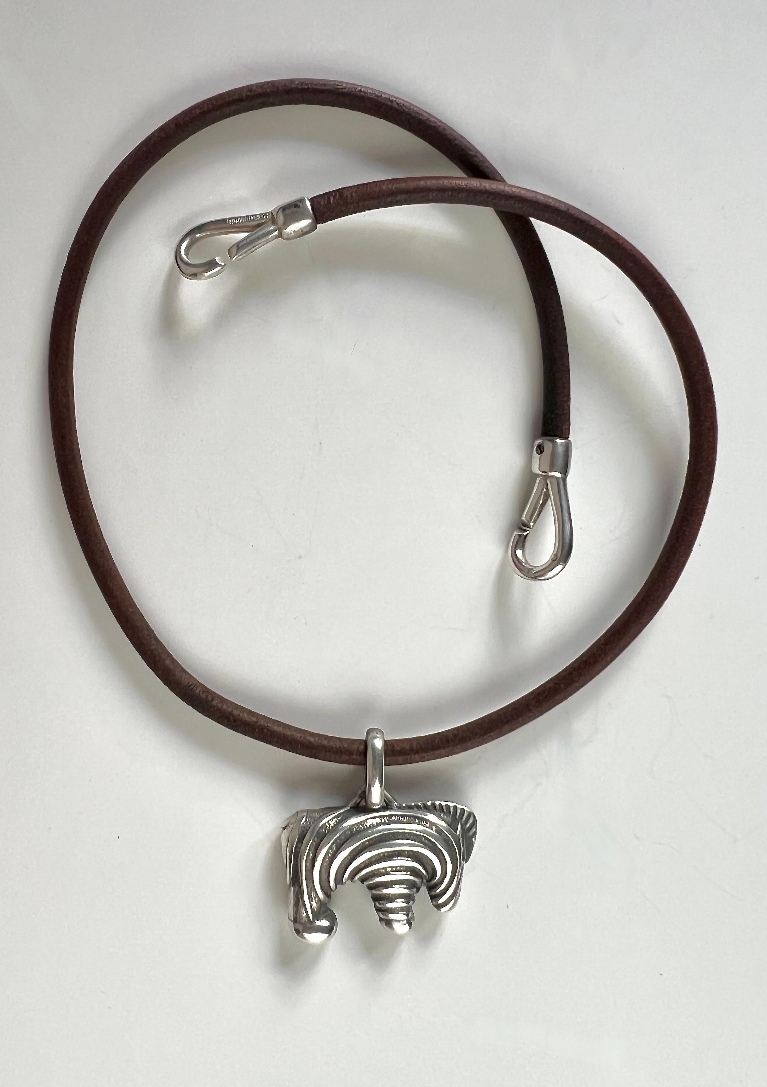 Hermès Vintage Selection by Corrado Luxury - Collana in cuoio con chiusura in argento punzonato, il pendente a forma di zebra sempre in argento finemente cesellato porta la firma Hermès. Il cuoio appare scuro e presenta segni di utilizzo .Si tratta